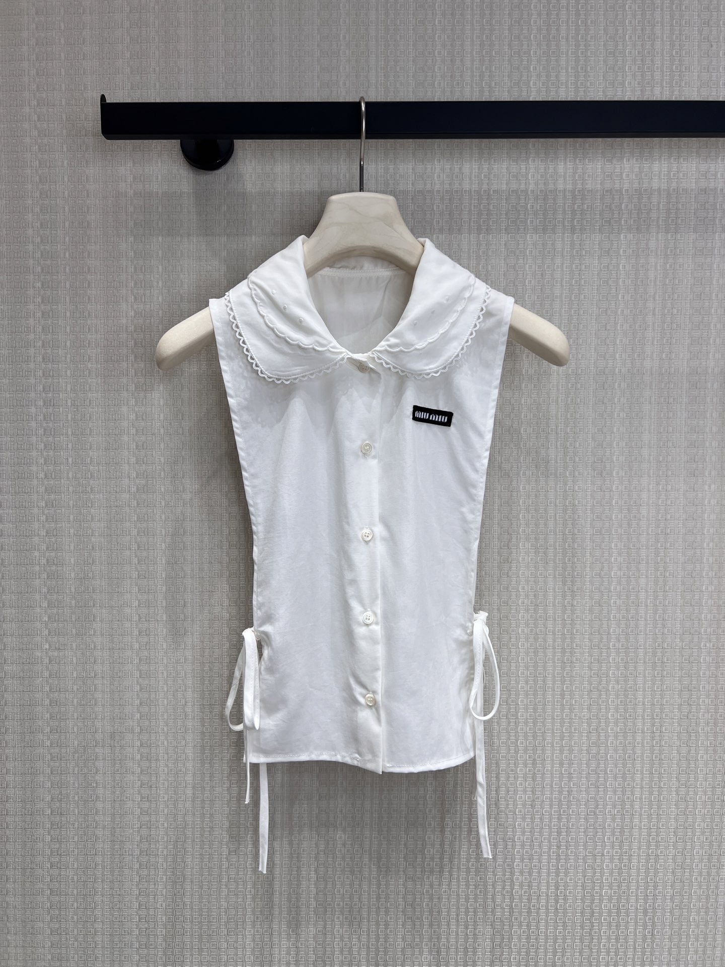 NO:858922,Miumi* 26Ss early spring new style letter micro-label embroidered sleeveless strappy shirt | Exclusively developed by yb!  Top quality production!  The classic shirt silhouette is combined with a sleeveless design to unlock a refreshing spring outfit. The delicate cotton fabric is soft and breathable, and the low-key letter micro logo embroidery on the chest highlights the brand recognition. The side straps can be adjusted freely to easily create a slim waistline. Whether worn alone or layered, it can create a sweet and cool girly look. Available now in S/M/L,, miumiu, shirts,19860909Miumi* 26Ss早春新款 字母微标刺绣无袖绑带衬衫丨独家yb开发！顶级高版出品！以经典衬衫廓形融合无袖设计,解锁春日清爽穿搭.细腻棉质面料柔软透气,胸前低调的字母微标刺绣彰显品牌辨识度,侧边绑带可自由调节松紧,轻松打造修身腰线.无论是单穿还是内搭,都能演绎出甜酷兼具的少女感.现货发售S/M/L,,miumiu,shirts,,Women's clothing