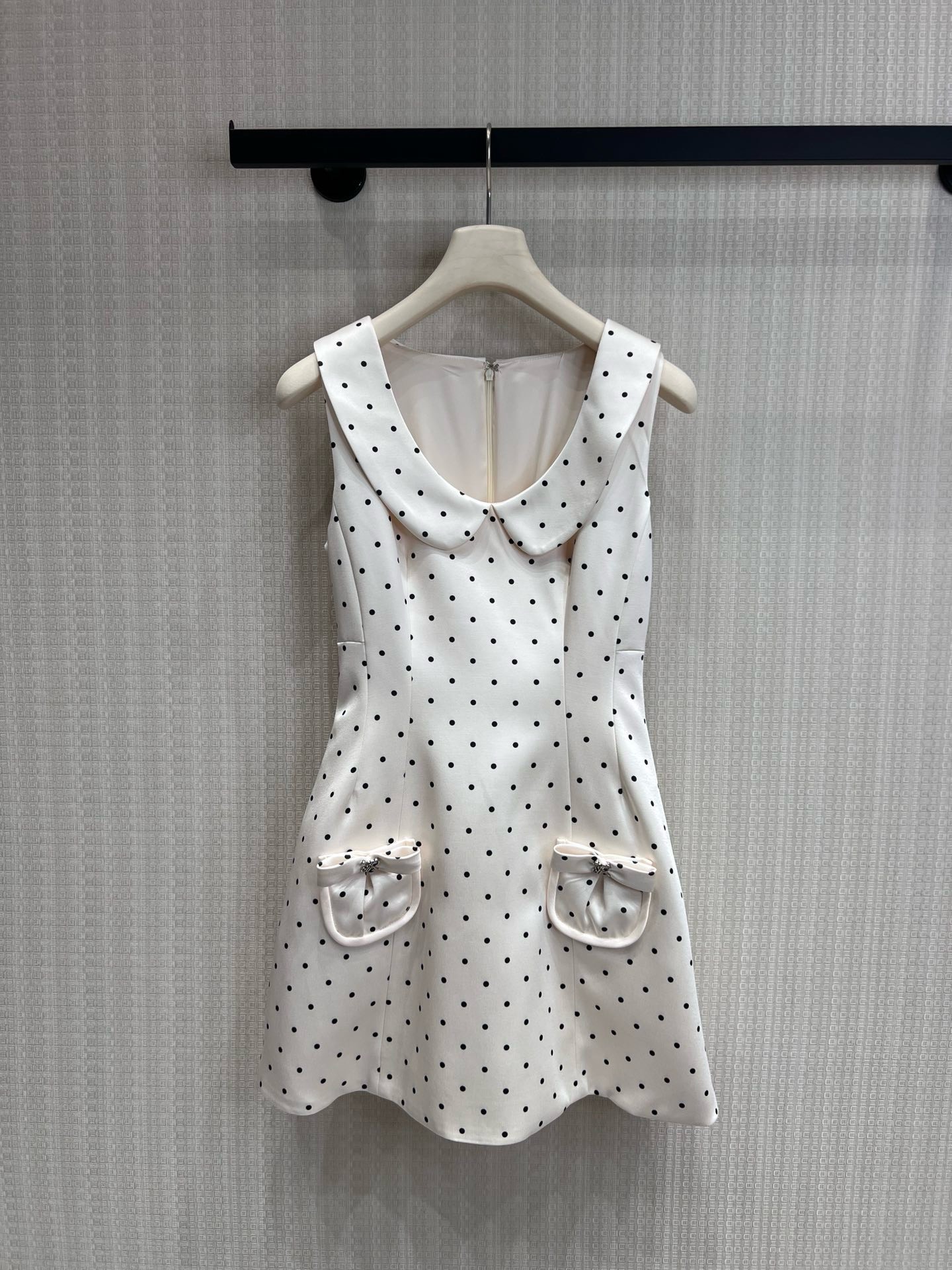 NO:844037,Original designer style 26 spring and summer new French retro polka dot doll collar sleeveless dress. A small white dress with an elegant filter. The classic black polka dots are paired with a milky white background, which brings out the French romance and girlishness. The exquisite doll collar gently reduces age, and the silhouette line on the chest hides the flesh. The A-line waistline skirt easily outlines the body curve, and the waist becomes slimmer and the legs become longer in seconds.  The bow pockets on both sides of the skirt are embellished with rhinestone buckles and are full of details. They can be worn on dates, commuting, and light gatherings. They can be worn alone or paired with suits and cardigans to create different styles. Available in stock sml, skirts, business suits,19860909原创设计师款 26春夏新品法式复古波点娃娃领无袖连衣裙 自带优雅滤镜的小白裙,经典黑波点搭配奶白底色,把法式浪漫与少女感拉满.精致娃娃领温柔减龄,胸前的廓形线条超藏肉,收腰A字裙摆轻松勾勒身材曲线,秒变腰细腿长. 裙摆两侧的蝴蝶结口袋,点缀水钻饰扣,细节感直接拉满,约会、通勤、轻聚会都能hold住,可单穿也可搭配西装、开衫打造不同风格.现货出售smL,,skirts,business suit,,Women's clothing