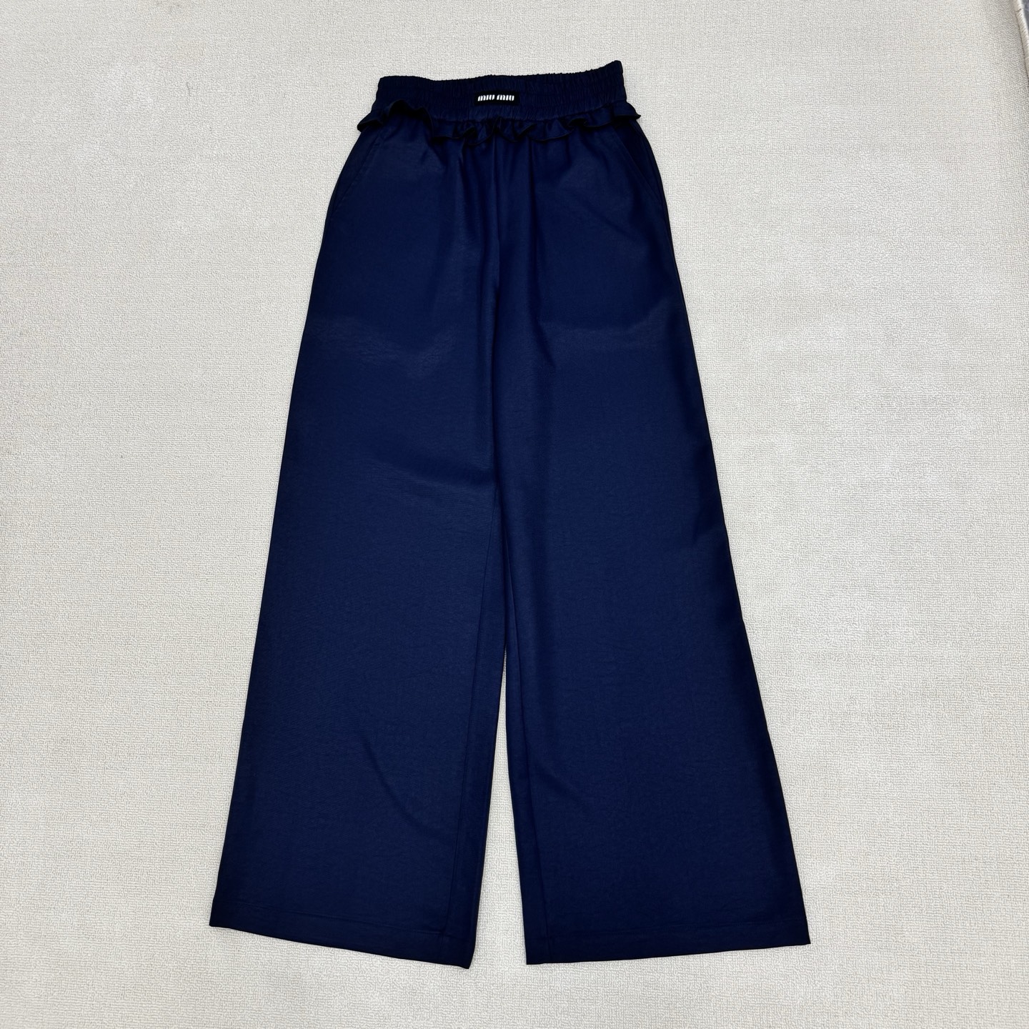 NO:844683,miumi*26Ss new spring and summer style casual pants with contrasting color letters, micro-marking and fungus stitching | Exclusive high-end version!  The iconic brand micro-labeled waistband brightens up the whole look, and the two-tone navy blue and off-white colors suit a variety of spring styles. It is made of crisp and drapey cotton blended fabric, with an elastic waist + wood ear edge splicing design.  The loose wide legs have a lazy and relaxed feeling. They can be paired with a short-sleeved vest and a cropped midriff top to create an American hot girl style. It is a core item in the summer wardrobe that is both recognizable and practical. Two colors are available in stock, S/M/L, miumiu, T-shirt,19860909miumi*26Ss春夏新款 撞色字母微标木耳边拼接休闲裤丨独家高版出品！以标志性的品牌微标腰头点亮整体,藏蓝色与米白双色调适配多元春日风格.采用挺括垂坠的棉质混纺面料,松紧腰+木耳边拼接设计 宽松阔腿自带慵懒松弛感,可搭配短袖背心短款露腰上衣打造美式辣妹风,是夏季衣橱里兼具辨识度与实穿性的核心单品.两色现货发售S/M/L,,miumiu,T-shirt,,Women's clothing