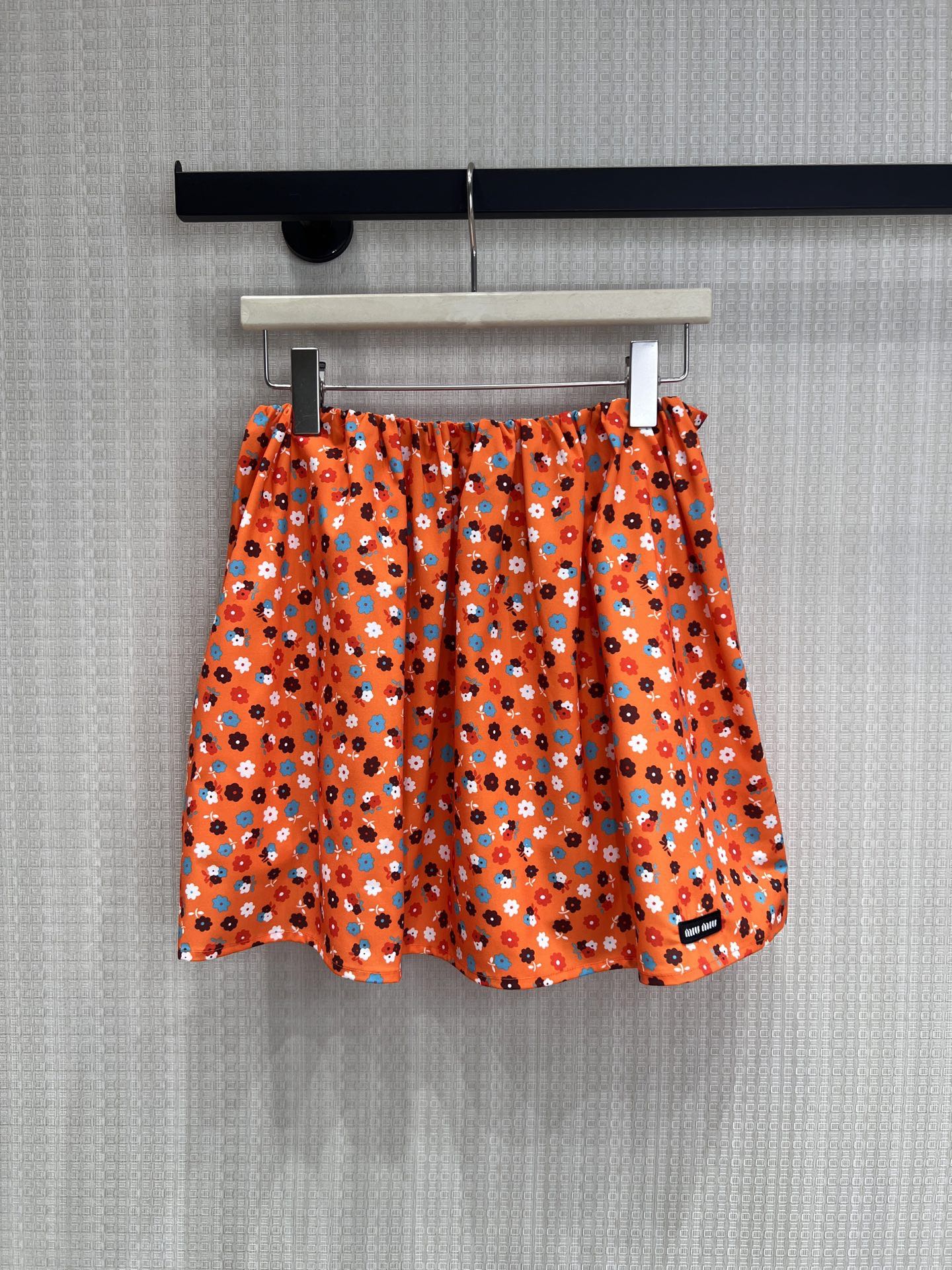 NO:863257,26 new spring and summer products Miu style vitality orange floral A-line short skirt to wear the freshness of spring on the body. The bright orange bottom is matched with small contrasting floral flowers, giving it a retro sweet girl atmosphere. The elastic waist is A-shaped, which is great for all waist types. It can easily hide the flesh of the crotch. The brand woven label on the side is low-key, and the details highlight the girlish feeling. The short skirt is long and the waistline is high, and it is full of vitality when paired with a white T and a sweater.  The refreshing fabric is draped and stylish. It is suitable for layering and wearing alone in spring and summer. It is easy to create a variety of styles. Ready for sale smL,, miumiu, skirts,1986090926春夏新品 Miu风元气橙碎花A字短裙 把春日的鲜活穿在身上 明艳橘底搭配撞色小碎花,自带复古甜妹氛围 松紧腰A字形,对各种腰型都超好,轻松藏住胯部肉肉侧边品牌织标低调点题,细节处彰显少女感 短款裙长拉高腰线,搭配白T、针织衫都是元气满满 清爽面料垂坠有型,春夏叠穿单穿都适配,轻松打造多种风格现货出售smL,,miumiu,skirts,,Women's clothing