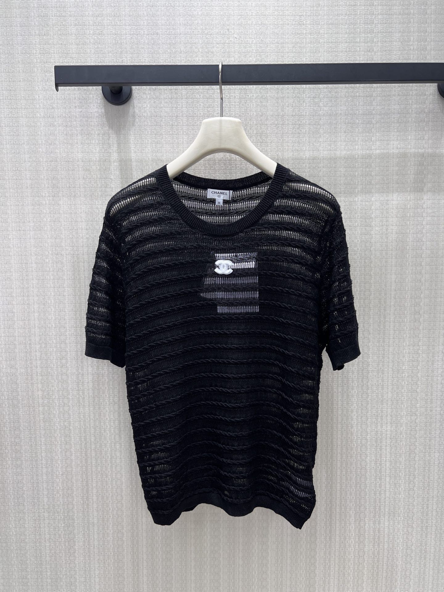 NO:867196,26 spring and summer new product Cha** knitted short-sleeve, black and white two-color interpretation of timeless elegant aesthetics. The textured wavy cable weave pattern with hollow design has a breathable feeling. The double C logo on the chest is a low-key accent, the round neck + short sleeves are neat and versatile, and the loose version is not picky about the body shape. It can easily adapt to commuting and daily life. It is a universal texture item in the wardrobe. Ready for sale smL, T-shirt,1986090926春夏新品 Cha**针织短袖,黑白双色诠释永不过时的优雅美学.肌理感波浪绞花织纹搭配镂空设计,自带透气呼吸感.胸前双C标识低调点睛,圆领+短袖剪裁利落百搭,宽松版型不挑身形,轻松适配通勤与日常,是衣橱里的万能质感单品.现货出售smL,,T-shirt,,Women's clothing
