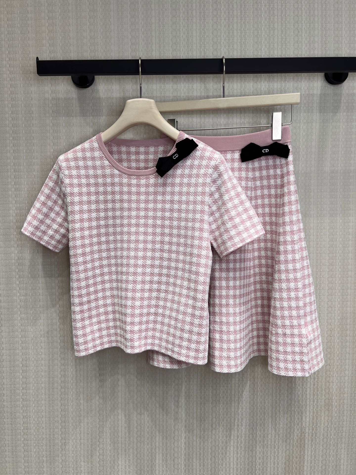 NO:874620,Top Skirt Dio** pink and white houndstooth woven elegant narrative, soft mist pink tone comes with a soft light filter. A round-neck short knitted top paired with an A-line skirt, replicating the French classic with delicate texture. The black bow CD logo on the collar and waist is a low-key and exquisite brand idea. It can be split and matched to unlock elegant styles in multiple scenes. Ready for sale smL, dior, skirts,19860909上衣 裙子 Dio**粉白千鸟格织就的优雅叙事,柔雾粉调自带柔光滤镜.圆领短款针织上衣搭配A字半裙,以细腻肌理复刻法式经典,领部与腰头的黑色蝴蝶结CD标识,是低调又精致的品牌巧思,可拆分搭配,解锁多场景优雅造型.现货出售smL,,dior,skirts,,Women's clothing