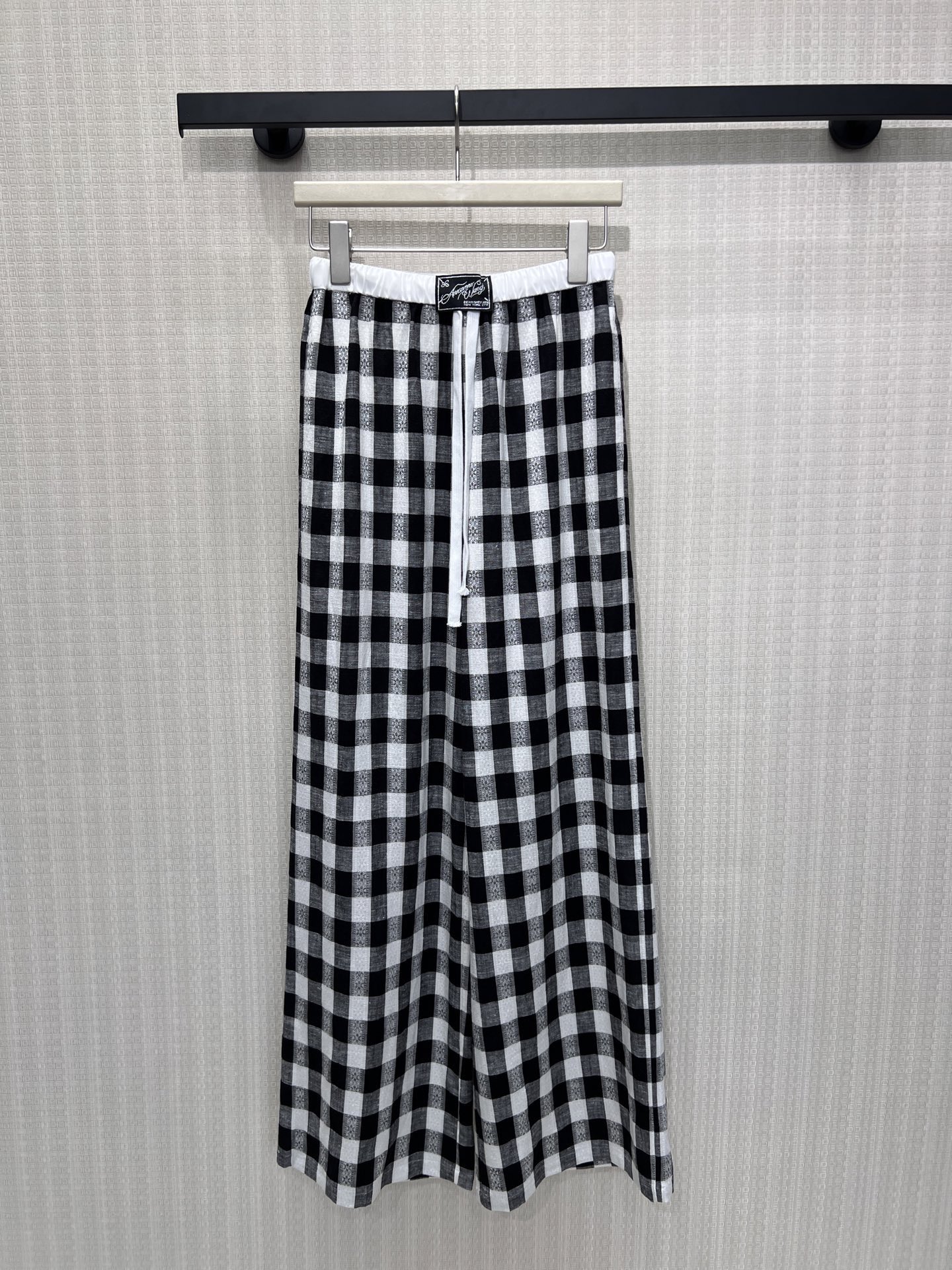 NO:877173,New Spring/Summer 26 Casual Pants. The classic black and white plaid pattern is given a relaxed narrative. The elastic waist and drawstring design are suitable for different body shapes and wearing scenarios. The drapey and breathable fabric has a lazy and relaxed feeling. The wide-leg version hides the flesh casually, and you can walk at your own pace. The exquisite labeling on the waist hides the brand's ingenuity. It is an effortless fashion expression, suitable for daily and casual scenes, and easily creates an unobtrusive high-end atmosphere. Ready for sale smL,,1986090926春夏新品 休闲裤 经典黑白格纹被赋予松弛叙事,松紧腰头与抽绳设计,适配不同身形与穿着场景.垂坠透气的面料,自带慵懒松弛感,阔腿版型随性藏肉,行走间尽是自在节奏.腰头精致贴标暗藏品牌巧思,是不费力的时髦表达,适配日常与休闲场景,轻松打造毫不刻意的高级氛围感.现货出售smL,,,Women's clothing