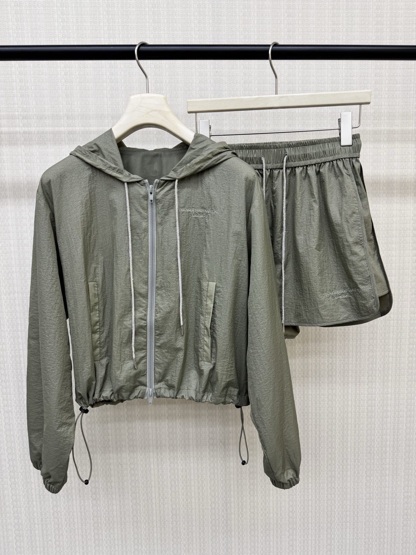 NO:877859,Alexande* Wan**26ss spring and summer new style fine diamond drawstring hooded sun protection jacket and elastic waist shorts suit. Brand letter embroidery on the chest and trousers as a set. Fully customized viscose fine diamond drawstring. Fully customized coated gold powder sunscreen fabric. The hem drawstring design is automatically shaped. It is extremely tolerant and super flesh-hiding. It is not picky about the figure. The exclusive customized gold powder sunscreen material sparkles under the light.  A must-have sunscreen artifact for summer. Two colors available for sale now. SML,,shorts,jackets & coats,hats,19860909Alexande* Wan**26ss春夏新款细钻抽绳连帽防晒外套松紧腰短裤套装 胸前与裤边品牌字母刺绣成套上下乎应 全定制粘胶细钻抽绳 全订制涂层金粉防晒面料,下摆抽绳设计自动塑型,包容性极强超级藏肉肉的一款,不挑身材.独家订制的金粉防晒料子更是在光线的衬托下闪闪灵动 夏季必备的一款防晒神器 两色现货发售 SML,,shorts,jackets & coats,hats,,Women's clothing