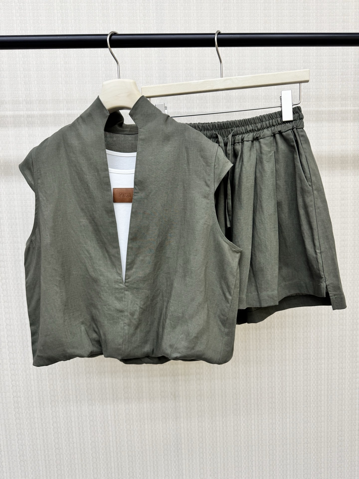 NO:878462,26ss summer new fend* fake two-piece top + drawstring elastic waist shorts linen suit. The fabric is breathable and comfortable. The top is combined with a vest fake two-piece design. The leather label badge embellishes the brand atmosphere. The loose-fitting upper body covers the flesh, the neckline is cut and cropped + small flying sleeves. The special tailoring and splicing of the vest and top are perfectly integrated. Two colors are available in stock. SML,,fendi,shorts,1986090926ss夏季新款fend*假两件上衣+抽绳松紧腰短裤亚麻套装 面料透气舒适 上衣拼背心假两件设计 皮标胸章点缀品牌气息.宽松版型上身超遮肉,领口一刀切剪栽+小飞袖 背心上衣特殊剪裁拼接完美融合 两色现货发售 SML,,fendi,shorts,,Women's clothing