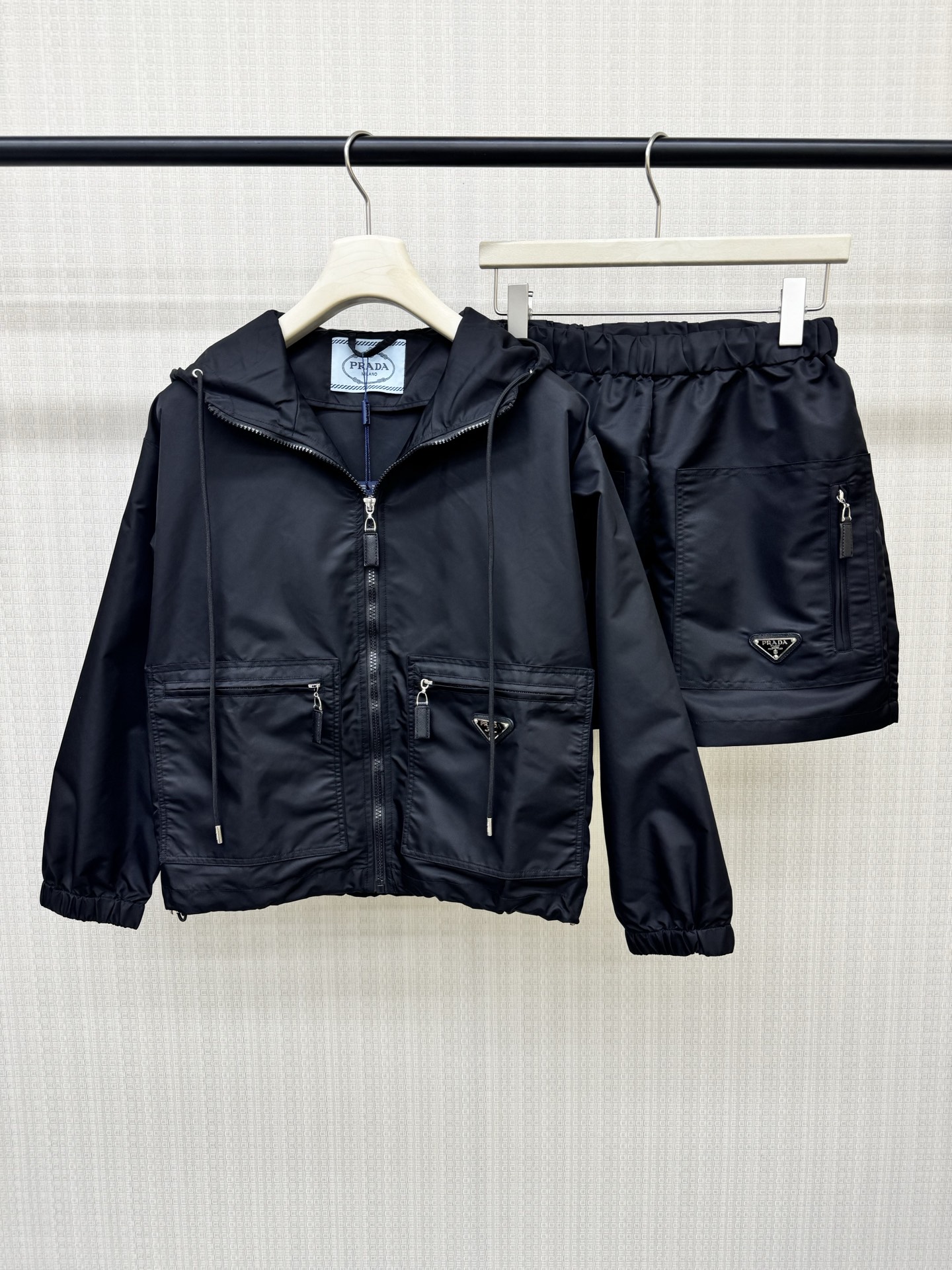 NO:890196,Jacket Shorts Pra** black eco-friendly nylon recycled hooded jacket + elastic waist shorts set. Lightweight nylon recycled material, windproof and comfortable, perfect for daily commuting or leisure!  Three logos + double zipper pockets on the chest, practical and recognizable. Curved tailoring + drawstring design, loose and tolerant, easy to create a relaxed look. Wear separately and easy to match. Easily switch between multiple styles, fashionable and practical. Get a set with multiple matching styles and easily control it. Available now. SML,, prada, shorts, jackets & coats, hats,19860909外套 短裤 Pra**黑色环保尼龙再生连帽外套+松紧腰短裤套装 轻量尼龙再生材质,防风又舒适,日常通勤或休闲都超适合！胸前三Logo+双拉链口袋,实用又有辨识度.弧形剪裁+抽绳设计,宽松包容,轻松打造松弛感穿搭.分开单穿易搭配 轻松切换多种风格,时髦又实用 入手一套多种搭配穿搭轻松驾驭现货发售 SML,,prada,shorts,jackets & coats,hats,,Women's clothing