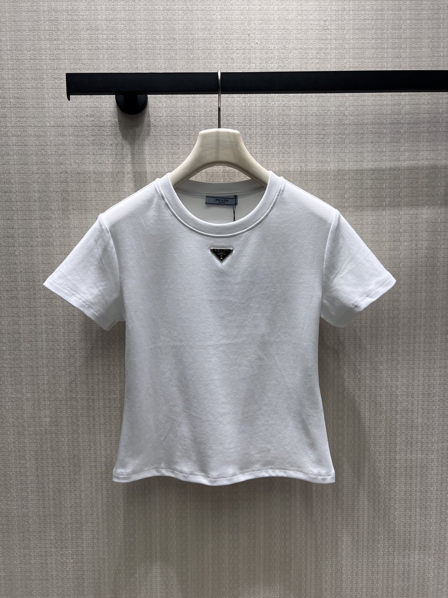 NO:893066,pra**26 new spring and summer products, minimalist basic short sleeves, classic metal triangle logo to establish recognition. High-count combed cotton is soft and waxy to fit the skin, matte fabrics are neat and not bulky, black and white are suitable for all wardrobes. The fitted short-cut version raises the waistline, the small round neck modifies the neck line, and the neat short-sleeved cut tightens the shoulder line and highlights the exquisite head-to-shoulder ratio. In stock smL, prada, T-shirt,19860909pra**26春夏新品 极简基础款短袖,经典金属三角徽标奠定辨识度.高支精梳棉软糯贴合肌肤,哑光面料利落不臃肿,黑白双色适配所有衣橱.合身短裁版型拉高腰线,小圆领修饰脖颈线条,利落短袖剪裁收紧肩线,衬出精致头肩比 现货smL,,prada,T-shirt,,Women's clothing