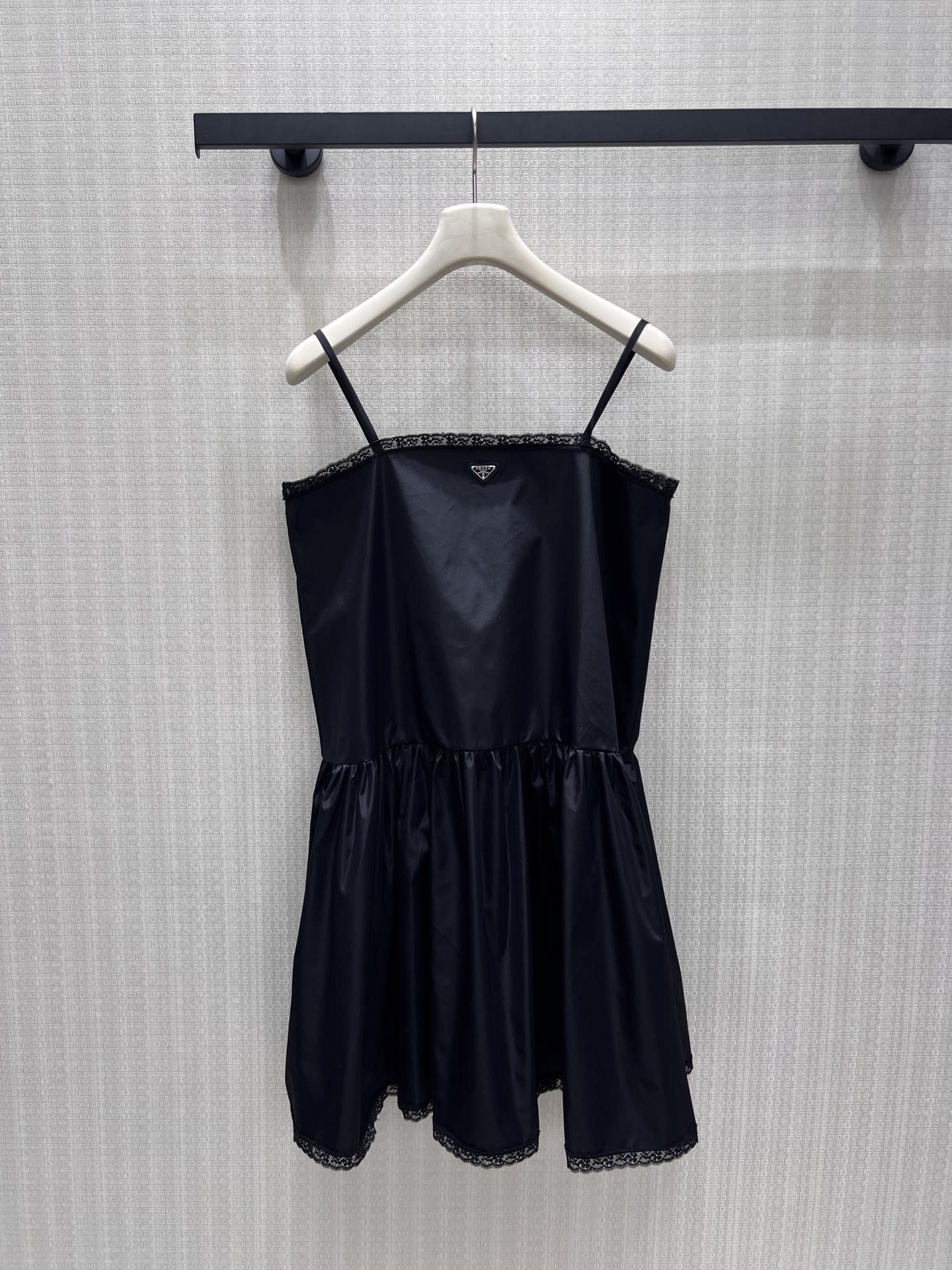 NO:898437,26 new spring and summer dresses  Pra**'s classic triangle logo sets the tone of elegance, and the shiny nylon has a low-key soft texture. Thin suspenders outline the soft lines of the shoulders and neck, and the delicate lace trim on the neckline and skirt adds a feminine atmosphere. The natural pleats at the waist and hem reveal a fluffy and draping skirt. Cool tone  The black color balances the sweet and cool temperament, and the neat short cut is light and smart. It is suitable for layering suits for commuting or wearing alone for appointments. It wears restrained girlish elegance on the body. Detailed pictures of real-life photos of sml in stock, prada, skirts, business  suit,1986090926春夏新品连衣裙 Pra**经典三角徽标定格优雅基调,亮面尼龙自带低调柔光质感.细吊带勾勒肩颈柔和线条,领口与裙摆细腻蕾丝镶边揉入柔媚氛围,腰部下摆自然抽褶散出蓬松垂坠裙摆.冷调黑平衡甜酷气质,利落短款剪裁轻盈灵动,通勤叠穿西装、单穿赴约皆适配,把克制的少女贵气穿在身上.现货smL实拍细节图,,prada,skirts,business suit,,Women's clothing