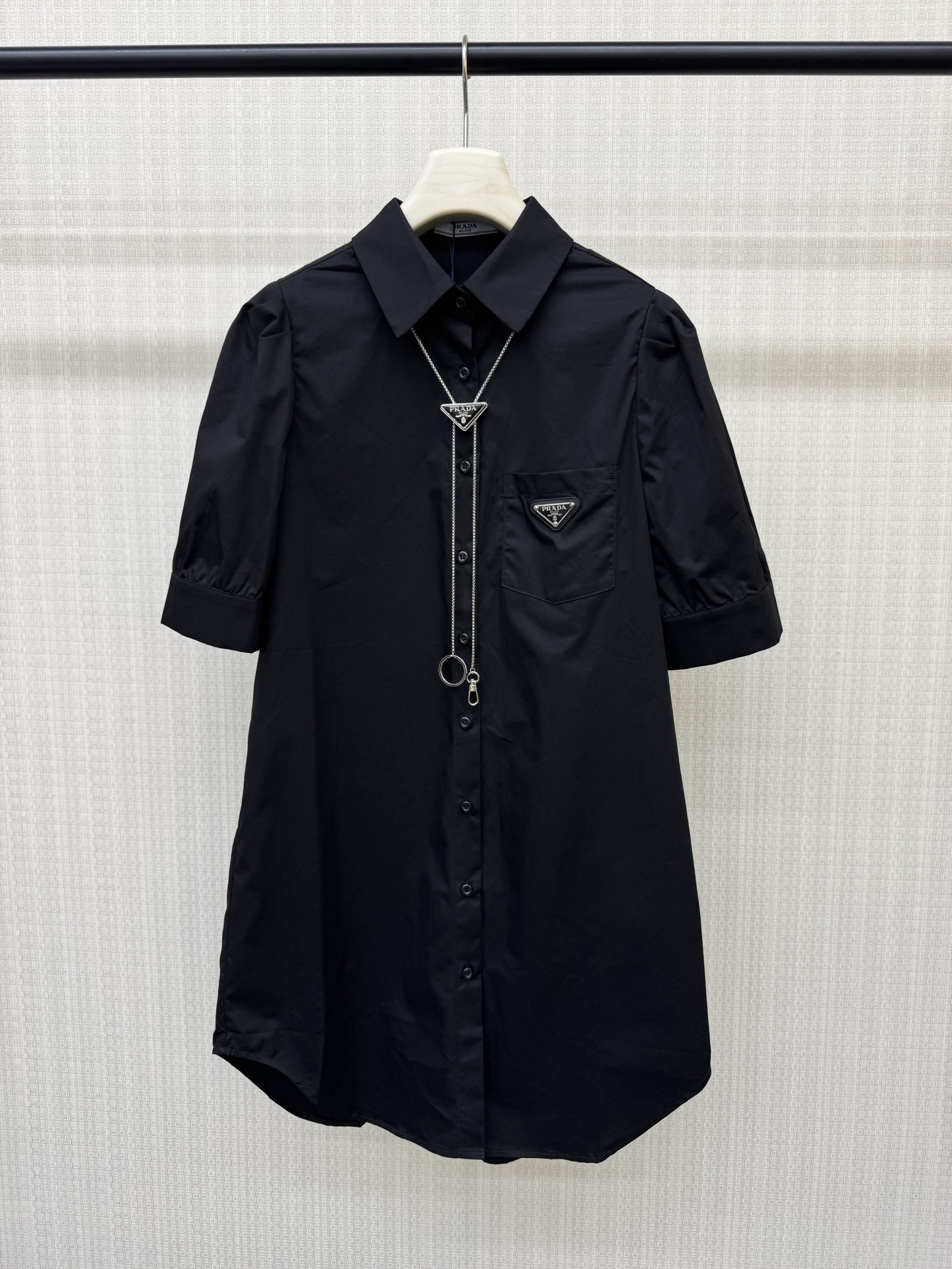 NO:893885,Pra**26 summer new triangle chain shirt dress, made of high-count washed cotton, dry, crisp and breathable, super comfortable to wear!  Lapel + full button placket + hardware triangle necklace. Five-point puff sleeves modify the arm lines, and the triangle metal logo on the left chest is very recognizable. The straight and loose mid-length version covers the hips and makes you slimmer. It is not picky about your figure. It looks great when worn alone or with accessories. It can be easily used for commuting, shopping, and traveling. It is practical and fashionable!  Black and white ready for sale sML real shot details, prada, skirts, shirts, necklace,19860909Pra**26夏季新款三角标链条衬衫连衣裙,高支水洗棉材质,干爽挺括又透气,穿着超舒适！翻领+全开纽扣门襟+配五金三角标项链 五分泡泡袖修饰手臂线条,左胸三角金属标超有辨识度.直筒宽松中长版型,遮胯显瘦,不挑身材,单穿或搭配配饰都很出彩,通勤、逛街、出游都能轻松驾驭,实用又时髦！黑色白色 现货发售sML实拍细节图,,prada,skirts,shirts,necklace,,Women's clothing