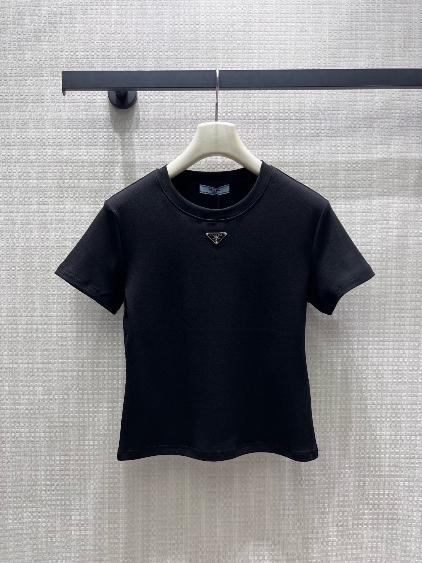 NO:952412,pra**26 new spring and summer products, minimalist basic short-sleeved style, classic metal triangle logo establishes recognition. High-count combed cotton is soft and waxy to fit the skin, matte fabric is neat and not bulky, black and white two-color suitable for all wardrobes. The fitted short-cut version raises the waistline, the small round neck modifies the neck line, and the neat short-sleeved cut tightens the shoulder line and highlights the exquisite head-to-shoulder ratio. Ready-made smL real shot details,, prada, T-shirt,19860909pra**26春夏新品 极简基础款短袖,经典金属三角徽标奠定辨识度.高支精梳棉软糯贴合肌肤,哑光面料利落不臃肿,黑白双色适配所有衣橱.合身短裁版型拉高腰线,小圆领修饰脖颈线条,利落短袖剪裁收紧肩线,衬出精致头肩比 现货smL 实拍细节图,,prada,T-shirt,,Women's clothing