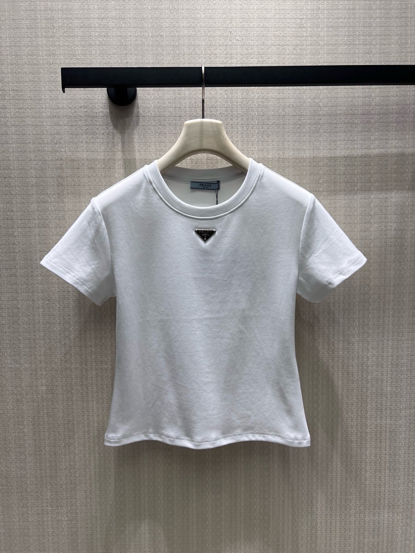 NO:952390,pra**26 new spring and summer products, minimalist basic short-sleeved style, classic metal triangle logo establishes recognition. High-count combed cotton is soft and waxy to fit the skin, matte fabric is neat and not bulky, black and white two-color suitable for all wardrobes. The fitted short-cut version raises the waistline, the small round neck modifies the neck line, and the neat short-sleeved cut tightens the shoulder line and highlights the exquisite head-to-shoulder ratio. Ready-made smL real shot details,, prada, T-shirt,19860909pra**26春夏新品 极简基础款短袖,经典金属三角徽标奠定辨识度.高支精梳棉软糯贴合肌肤,哑光面料利落不臃肿,黑白双色适配所有衣橱.合身短裁版型拉高腰线,小圆领修饰脖颈线条,利落短袖剪裁收紧肩线,衬出精致头肩比 现货smL 实拍细节图,,prada,T-shirt,,Women's clothing