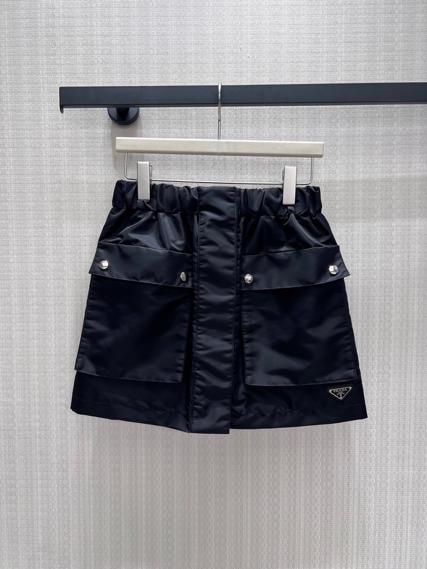 NO:952447,26 spring and summer new skirt Pra** classic nylon skirt, integrating workwear aesthetics and urban neatness. The crisp nylon fabric has a matte texture, the bud waistband is equipped with three-dimensional workwear pockets, and the silver rivets and triangular logo hide the brand genes. The neat short cut optimizes the proportions, has both a cool and high-end feel, and can easily create an effortless high street look. Ready for sale sml real shot details, prada, skirts,1986090926春夏新款半裙 Pra**经典尼龙半裙,将工装美学与都市利落感融为一体.挺括尼龙面料自带哑光质感,花苞腰头搭配立体工装口袋,银色铆钉与三角徽标暗藏品牌基因.利落短款剪裁优化比例,兼具酷飒与高级感,轻松打造不费力的高街造型.现货出售smL 实拍细节图,,prada,skirts,,Women's clothing