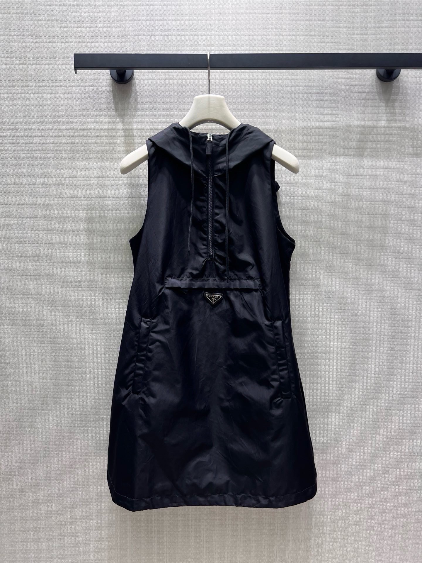 NO:952465,26 spring and summer new product Pra** nylon sleeveless hooded skirt, with a minimalist silhouette to demonstrate a pioneering attitude. The half-open zipper and iconic triangle logo integrate the brand genes into daily life. The crisp fabric has a neat drape, and the loose version accommodates all body shapes. The black tone is full of texture, and it is easy to wear with a casual and high-end cool atmosphere. Ready-made sml real shot details, prada, skirts, hats,1986090926春夏新品 Pra**尼龙无袖连帽裙,以极简廓形演绎先锋态度.半开拉链与标志性三角徽标,将品牌基因融入日常,挺括面料自带利落垂坠感,宽松版型包容所有身形,黑调质感拉满,轻松穿出随性又高级的酷飒氛围.现货smL 实拍细节图,,prada,skirts,hats,,Women's clothing