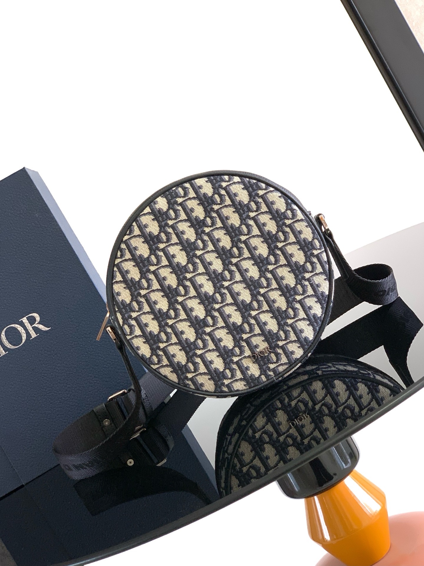 这款 Dior Yoyo 拉链信使包时尚实用。圆形款式,采用米色和黑色 Oblique 印花面料等材质