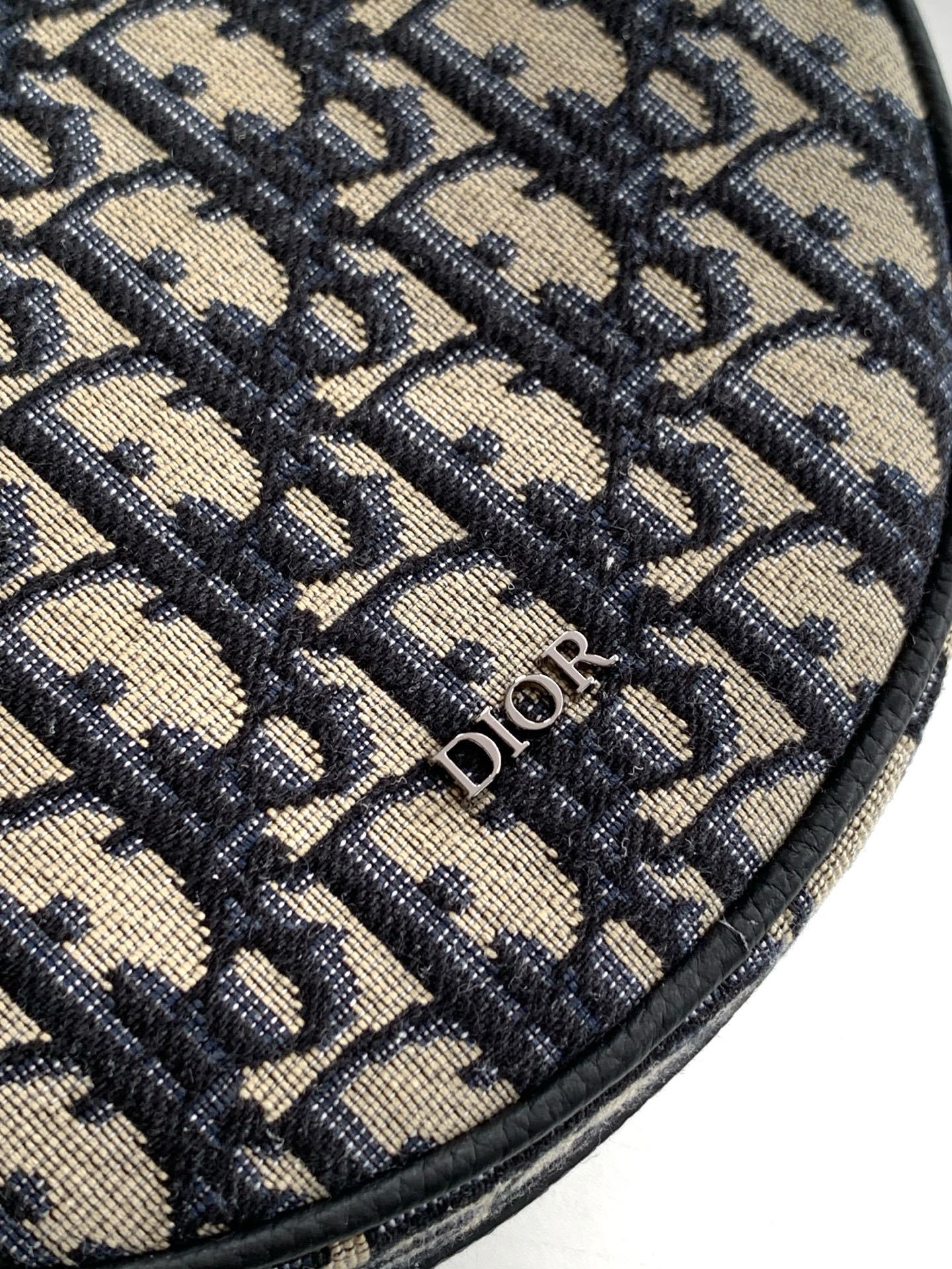 这款 Dior Yoyo 拉链信使包时尚实用。圆形款式,采用米色和黑色 Oblique 印花面料等材质