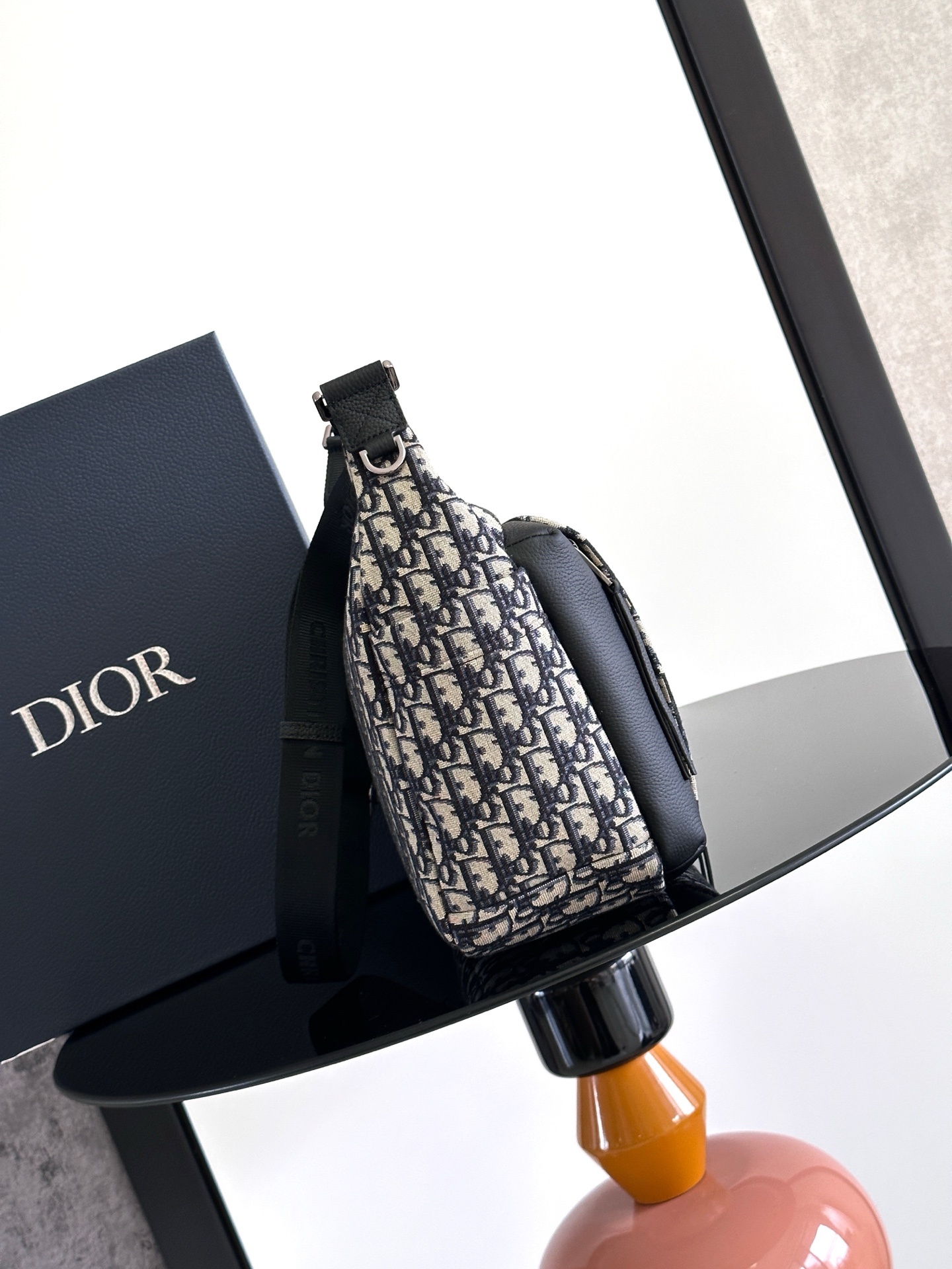 这款 Rider Soft 水饺包是二零二五秋季男装系列新品,兼具实用功能与时尚设计。采用米色和黑色 O