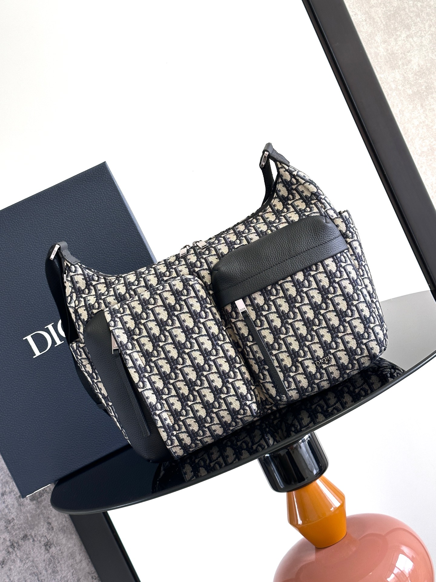 这款 Rider Soft 水饺包是二零二五秋季男装系列新品，兼具实用功能与时尚设计。采用米色和黑色 O