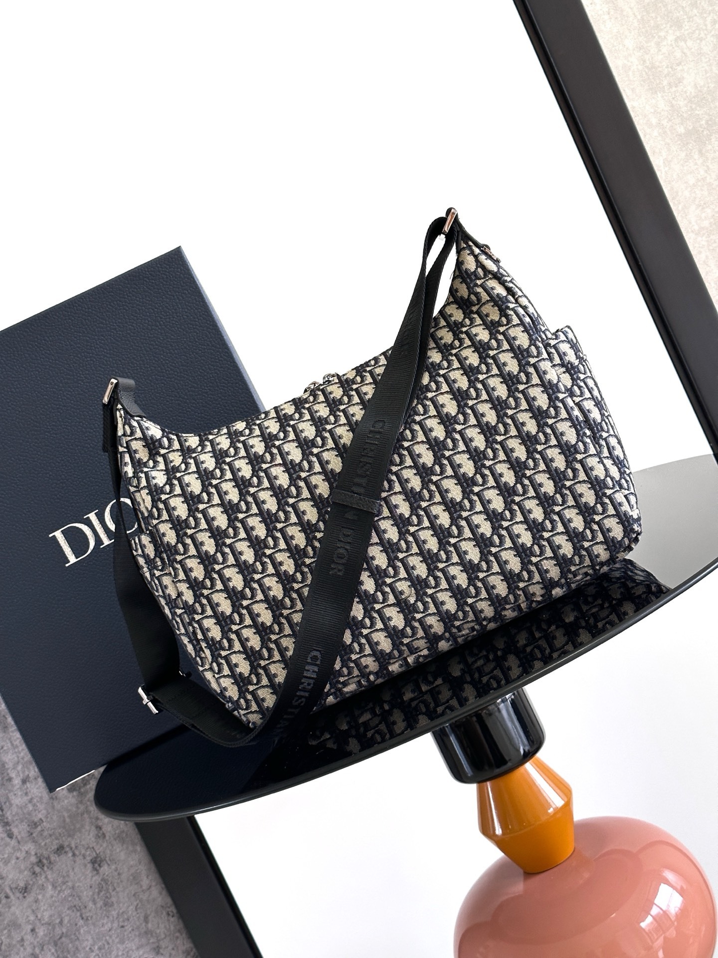 这款 Rider Soft 水饺包是二零二五秋季男装系列新品,兼具实用功能与时尚设计。采用米色和黑色 O