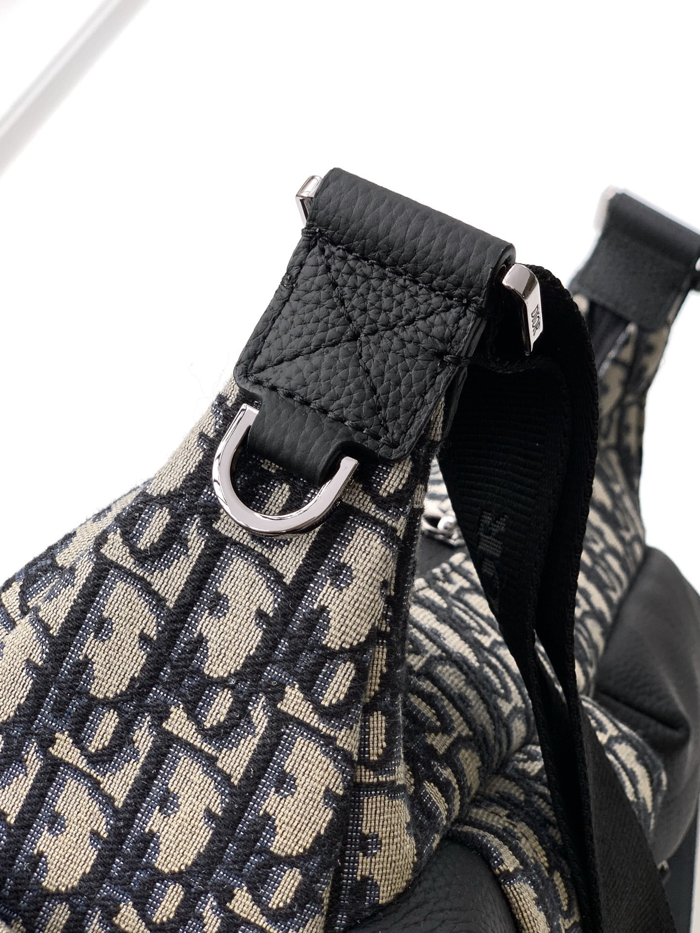 这款 Rider Soft 水饺包是二零二五秋季男装系列新品,兼具实用功能与时尚设计。采用米色和黑色 O