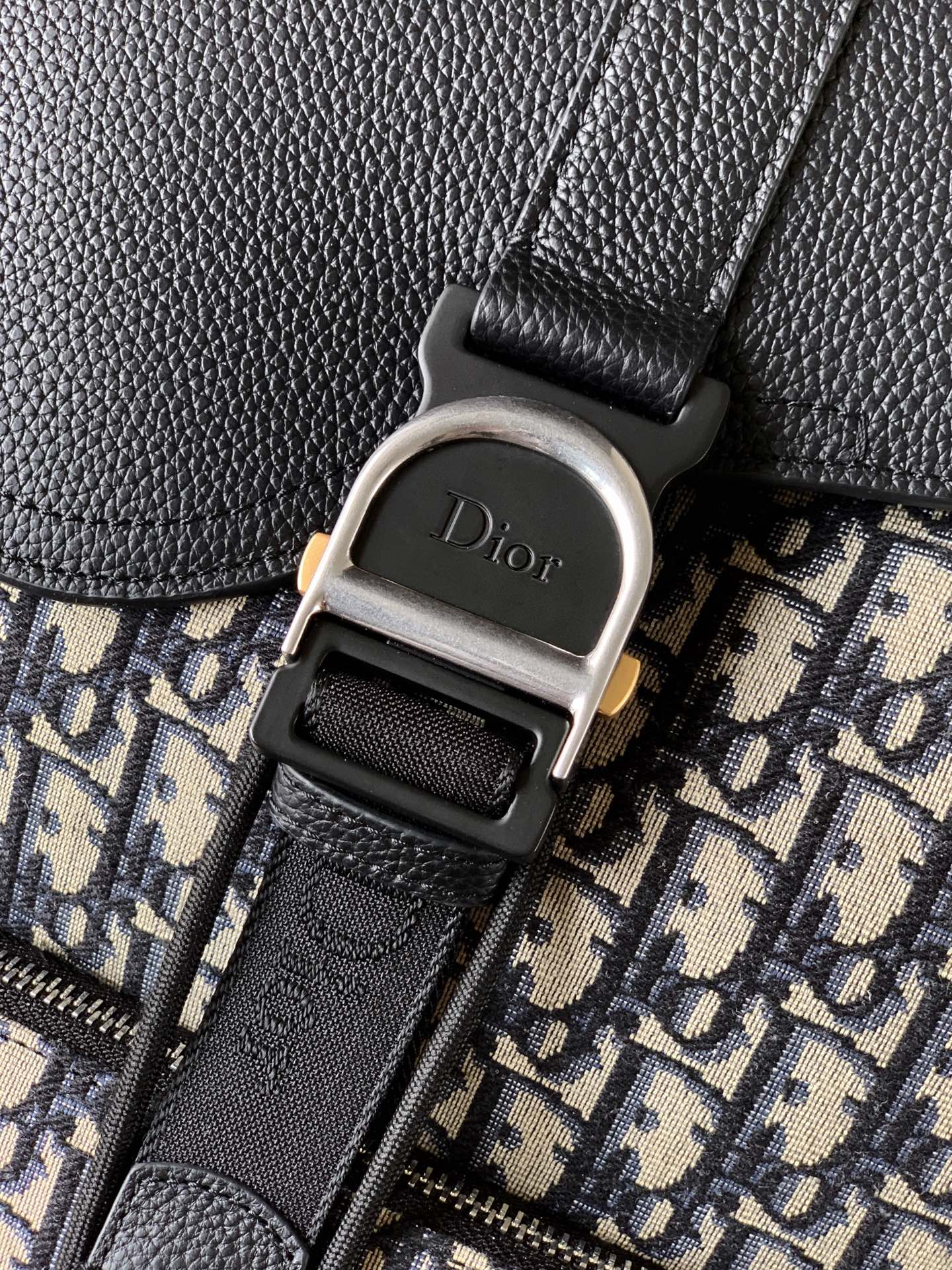 Dior 这款 Heritage 马鞍翻盖双肩背包采用