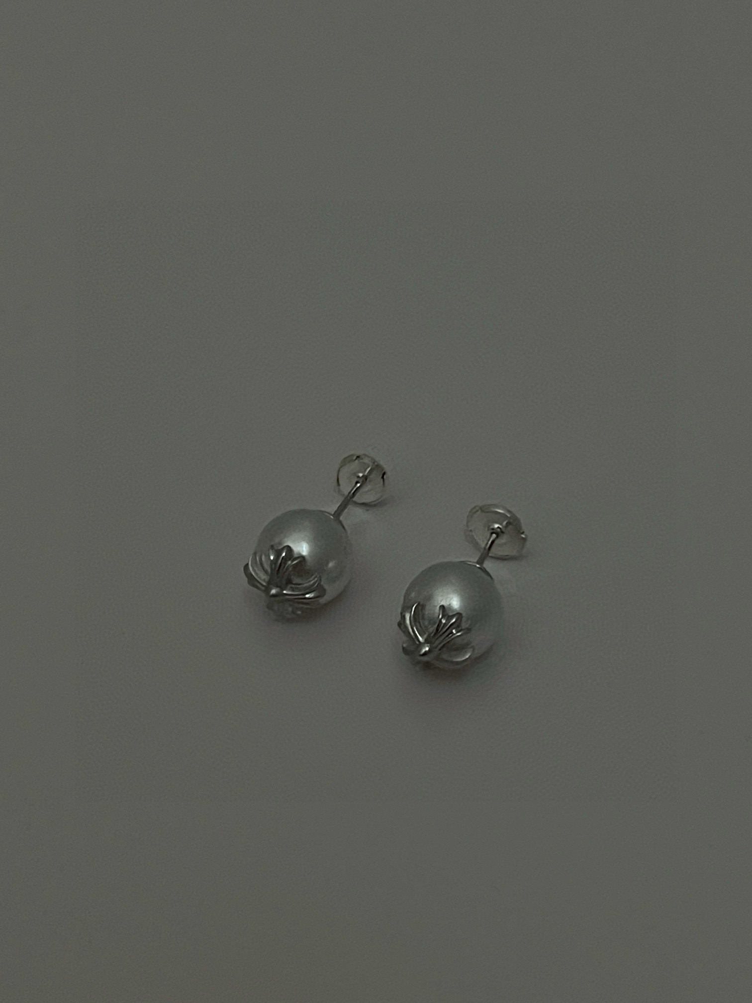  克罗心×Mikimoto 御木本联名款的耳钉，巧妙将女性气质的白色珍珠与 Chrome Hearts 