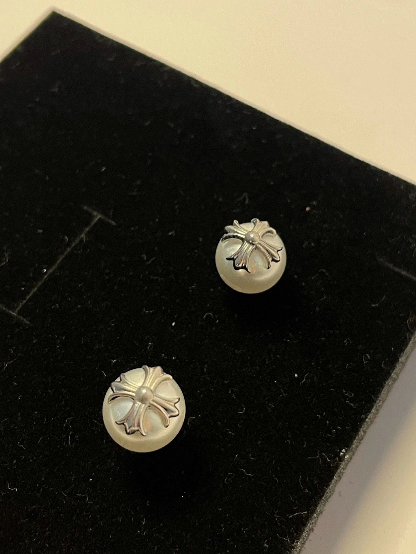  克罗心×Mikimoto 御木本联名款的耳钉，巧妙将女性气质的白色珍珠与 Chrome Hearts 