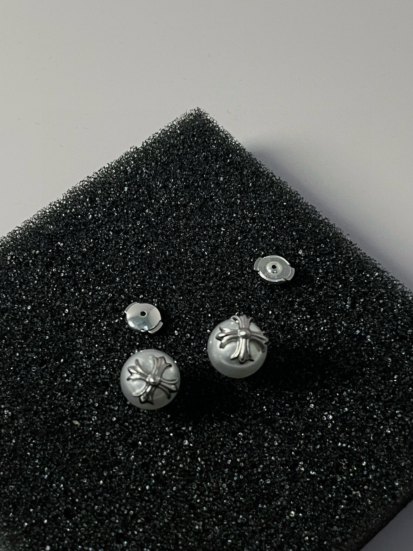  克罗心×Mikimoto 御木本联名款的耳钉，巧妙将女性气质的白色珍珠与 Chrome Hearts 