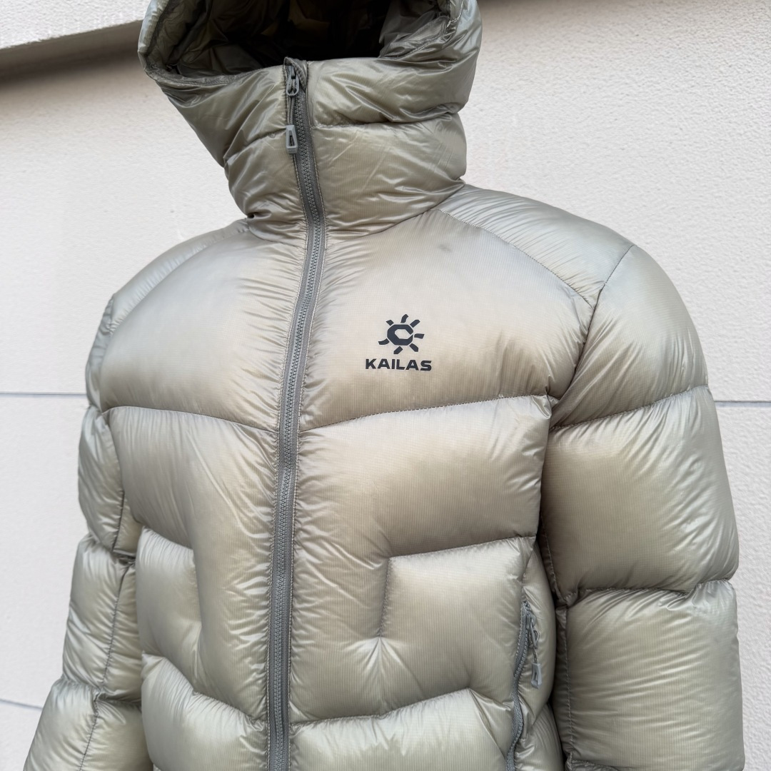 私域版高货!KAILAS 凯乐石 5000GT 千蓬元帅户外运动登山徒步轻量透气拒水1000蓬羽绒服 超级轻薄半透面料,绒朵透光可见,所以这款填充绒必须足够好,否则没法看! 肉眼可见的超级蓬松,这款因为填充的绒朵好,才能呈现出鼓鼓囊囊的效果,超轻超蓬! 填充国标拒水90白鹅绒(清水绒),支持检测!区别于市面假90绒. 面料为涤纶暗格,市面无同款面料,定制定染色后再做防水;为还原原版质感与手感,打样无数次才最终满意.里布工艺同样复杂,生产周期漫长. 所有五金辅料均为定制定染色:整衣采用三种不同拉链头,内里口袋配特殊色拉链,帽子及下摆抽绳、帽子气眼,均攻克极高工艺难度,完美呈现. 尺码建议:版型偏大,原版数据一刀未改,且可通过下摆内侧抽绳调整至合适效果. 产品配色:松翠绿、玉雪粉、暗泉绿、玄铁黑、天池蓝乌木灰