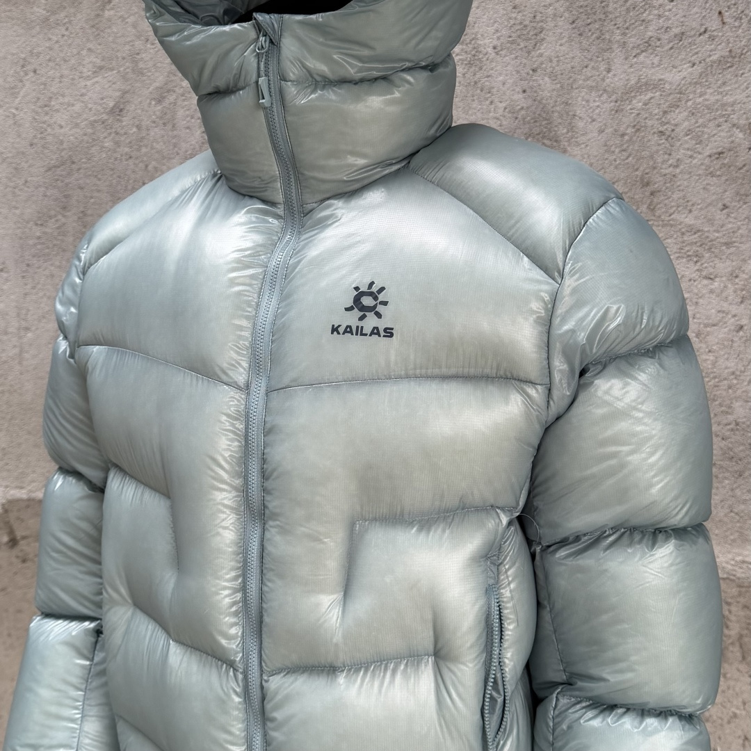 私域版高货!KAILAS 凯乐石 5000GT 千蓬元帅户外运动登山徒步轻量透气拒水1000蓬羽绒服 超级轻薄半透面料,绒朵透光可见,所以这款填充绒必须足够好,否则没法看! 肉眼可见的超级蓬松,这款因为填充的绒朵好,才能呈现出鼓鼓囊囊的效果,超轻超蓬! 填充国标拒水90白鹅绒(清水绒),支持检测!区别于市面假90绒. 面料为涤纶暗格,市面无同款面料,定制定染色后再做防水;为还原原版质感与手感,打样无数次才最终满意.里布工艺同样复杂,生产周期漫长. 所有五金辅料均为定制定染色:整衣采用三种不同拉链头,内里口袋配特殊色拉链,帽子及下摆抽绳、帽子气眼,均攻克极高工艺难度,完美呈现. 尺码建议:版型偏大,原版数据一刀未改,且可通过下摆内侧抽绳调整至合适效果. 产品配色:松翠绿、玉雪粉、暗泉绿、玄铁黑、天池蓝乌木灰