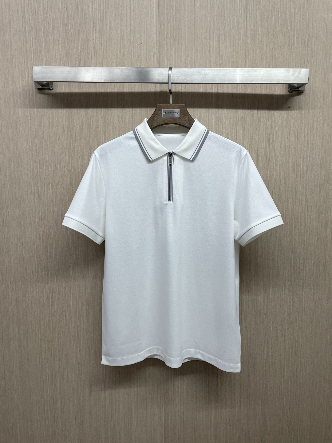 NO:827624,High version men's hexagonal piqué flat knitting half-zip Polo collar short-sleeved T-shirt. Exquisite craftsmanship, high-end texture, and classic items are the keywords of Italian style dressing. They are also the 'old money' tone of LP. The classic Polo shirt is reinterpreted with LP's tone. It is very clean fit and also very old money.  The mercerized flat machine rib lapel is high-density and has excellent glossy texture. The outer ring of the lapel is contrasted with jacquard stripes. The color of the stripes echoes the inlay strips of the half-zip placket, making the lapel and placket very eye-catching. In addition to adding strips, the inner circle of the lapel is also inlaid with half a thin orange webbing. The large body is fitted and cut with just the right amount of looseness. The minimalist and exquisitely hung Polo shirt is an expensive item at first glance.  The standout point of the craftsmanship is that the cuffs and hem are both made using a unique flat knitting process, with seamless ribbing that is integrated with the body, similar to the processing technology of sweaters, and the cutting and sewing of unconventional fabrics, which is enough to distinguish it from ordinary T-shirts. Men's clothing, loro piana, T-shirt, tees, t-shirt,19860909高版 男款六角珠地横机织造工艺半拉链POlO领短袖T恤 精致工艺、高级质感、经典单品,这些都是意式穿搭的关键词,也是LP骨子里的“老钱”腔调,以LP的调性重新演绎的经典POlO衫,很Clean Fit,也很old money. 丝光色织扁机罗纹翻领,高密度且光泽质感优秀,翻领外圈撞色了提花条纹,条纹的配色与半拉链门襟的镶嵌条正好呼应,衬得翻领和门襟很是醒目.翻领的内圈在加了衬条之外,还镶嵌了半截细细的橘色织带.大身松量正好的合体剪裁,极简且精致挂的POlO衫,一眼显贵的单品. 工艺上脱颖的点在于,袖口及下摆均是采用独到的横机织造工艺,无接缝衔接了与大身一体的罗纹收口,类似于针织衫的处理工艺,非常规面料的裁剪缝制,这足以区别于普通的T恤.,男装,loro piana,T-shirt,tees，t-shirt,,Women's clothing