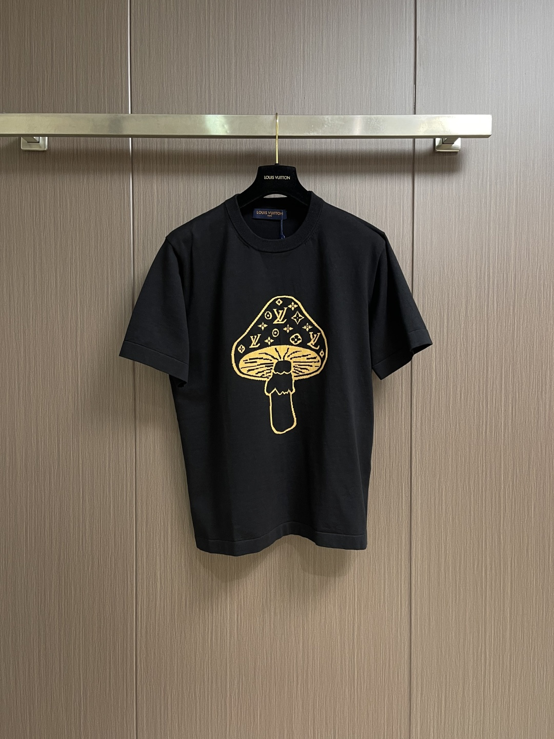 NO:598766,LV  Mushroom knitted intarsia round neck short-sleeved T-shirt. The T-shirt is made of high-quality knitted fabric, with a soft and crisp texture. The black warp adjustment is versatile. The round neck structure is precision seamed and the collar fits the neck and is not easy to deform. The mushroom pattern on the front is made of jacquard knitting technology, and the golden silk thread is in line with the brand's classic  The classic logo is integrated, and the texture is three-dimensional and delicate, highlighting the brand's high recognition. The body is sewn using industrial-grade flat stitching technology, the stitches are smooth and even, and the stitching at the hem and cuffs is fine and firm. From the selection of knitted fabrics to the process control of jacquard patterns, every process embodies Louis  Vuitton's pursuit of technological precision and creative design not only retains the daily practicality of T-shirts, but also shows the brand's light luxury recognition through unique jacquards. It is a fusion of knitting technology and fashion design. The overall routing is straight and delicate, the fabric is comfortable and soft, and the colors are consistent without color difference. It can be matched with the same style to create a fashionable look and control various occasions. Customized accessories, complete three labels, the same style for men and women!  Size S-XL,,louis vuitton,louis vuitton,T-shirt,tees,t-shirt,alexander wang19860909LV 蘑菇针织嵌花圆领短袖T恤,该T恤选用高品质针织面料,质地柔软且挺括,黑色调经百搭.圆领结构经精密锁边工艺,领口贴合颈部且不易变形.正面蘑菇图案采用提花针织工艺,金色丝线与品牌经典标识融合,纹理立体细腻,彰显品牌高辨识度.衣身车缝采用工业级平缝工艺,线迹平整均匀,下摆与袖口处针距细密牢固.从针织面料的甄选到提花图案的工艺把控,每一道工序都体现Louis Vuitton对工艺精度与创意设计的追求,既保留T恤的日常实穿性,又通过独特提花展现品牌的轻奢辨识度,是针织工艺与时尚设计的融合之作.整体走线平直细腻,面料舒适柔软,颜色一致无色差 能与同款搭配营造时尚造型,驾驭各种场合,定制辅料,三标齐全,男女同款！尺码S-XL,,louis vuitton,louis vuitton,T-shirt,tees，t-shirt,alexander wang,Men's clothing