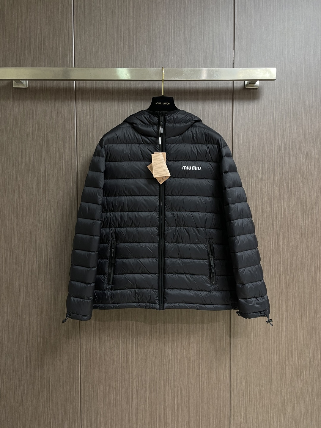 NO:651591,MIUMIU The embroidered hooded down jacket is made of high-end nylon fabric made of high-count polyamide fiber. It is famous for its excellent tensile strength and wear resistance. Its good flexibility makes the fabric less prone to wrinkles and keeps it crisp and stylish for a long time. The tight weave effectively blocks the invasion of cold wind and locks in the warm air generated by the down layer. The surface of high-density nylon forms a certain amount of charge. Leaf effect, small water droplets are not easy to penetrate, keeping the interior dry, effectively extending the service life of the down. It uses 90 national standard high-quality down, with a filling capacity of 180 grams. It has high fill power, strong warmth retention, lightness and no burden, and can easily cope with cold weather. Whether it is urban commuting or outdoor leisure, this hooded down jacket has excellent performance and simple design. It has become an indispensable item in the winter wardrobe. The logo adopts imported machine embroidery technology, using advanced computer control systems and precision mechanical components to achieve mimiu embroidery operations with high precision, smooth and delicate lines. Imported No. 7 needles + anti-velvet fine seams are used, with 13 stitches every three centimeters. The stitches are straight and do not skip stitches. Both sides of the zipper are equipped with The fabric of the cover is wrapped and sewn, so that when viewed from the front and side, the zipper teeth and chain straps are almost invisible. The hemming does not stop at the collar, but continues upward, and only a coherent and flat suture line can be seen. It achieves perfect windproof continuity and creates a smooth and advanced line sense. Sizes 46-52,,miumiu,down jacket,hats,alexander wang19860909MIUMIU 饰刺绣连帽羽绒服,面料选用高支数的聚酰胺纤维打造的高端尼龙面料,以出色的抗拉强度和耐磨性能著称,其良好柔韧性使面料不易起皱,长久保持挺括有型.紧密的织法有效阻挡冷风侵袭,锁住羽绒层产生的暖空气.高密度尼龙表面形成一定的荷叶效应,小水滴不易渗透,保持内部干爽,有效提升羽绒使用寿命.采用90国标高品质羽绒,充绒量达到了180克,蓬松度高、保暖性强,轻盈无负担,轻松应对寒冷天气.无论是都市通勤还是户外休闲,这件连帽羽绒服皆以出色性能和简约设计,成为冬季衣橱中不可或缺的单品,徽标采用进口机刺绣工艺,使用先进的计算机控制系统和精密的机械部件,实现mimiu刺绣作业,精度高、线条流畅且细腻.选用进口7号针＋防绒细线缝,每三公分达13针,线迹顺直,不跳针.拉链的两侧被配套的面料包裹缝合,使得从正面和侧面看,几乎看不到拉链的齿和链带,包边不是到领口就停止,而是继续向上,只能看到一条连贯、平整的缝合线.实现完美的防风连续性,更创造了流畅,高级的线条感.尺码46-52,,miumiu,down jacket,hats,alexander wang,Men's clothing