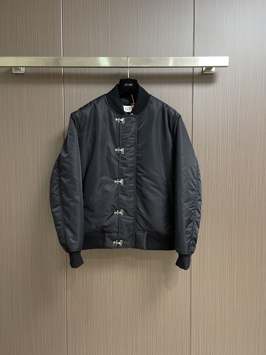 NO:597936,Loewe hook-and-buckle bomber cotton jacket is custom-woven with Pan Yao technology nylon and elegant cavalry diagonal green lining. It is full of texture, thick and solid, and every inch contains a heavy warmth. The outer layer is mainly made of unique satin black, and the inner layer is deep dark green undercurrents. It reconstructs the cold aesthetics of winter. The side hooks are hidden in the folds of the fabric. The front zipper becomes an invisible seam. Minimalist paranoia. Back panel LOEWE  The leather logo highlights the brand style. It reveals endless luxury and charm in a low-key manner. It redefines the dignity of winter wear. A silent declaration of noble status. Prioritizes the use of computer-aided (CAD) software. Accurate path. Re-positioning for punching and then purely manual work according to the positioned path. Hooks and buckles are sequentially stamped by machine according to the template. Every detail is crafted with ingenuity. Complex and cumbersome workmanship. Low daily output. High loss. Expensive processing unit price. Purely manual disassembly process.  After completing the initial combination of the lining cloth and the cotton piece, the craftsman will make further adjustments and disassembly in the water. The lining cloth and the cotton piece can achieve a perfect combination, making the lining cloth and the cotton piece more closely combined. Beautiful and neat. The template machine opens the bag. The preset template guides the position, shape and size of the bag opening. The accuracy ensures the quality of the bag opening effect. Sizes 48-54 S-XL,, loewe, jackets & coats, silk fabric, alexander wang19860909Loewe 钩扣飞行员棉服外套 定制密织磐曜科技尼龙 以及奢雅骑兵斜幽绿茵里衬布 质感十足 厚重扎实 每一寸都蕴含着沉甸甸的暖意 外层以独特绸缎黑为主色调里层深邃墨绿暗涌 重构冬季的冷感美学 侧面钩扣隐匿于织物褶皱正面拉链化作一条隐形缝线 极简主义的偏执 后幅LOEWE 皮革标识彰显品牌风范 低调中透露着无尽的奢华与韵味 重新定义冬季穿着的尊严 尊贵身份的无声宣言 优先使用计算机辅助（CAD）软件 精准路径 再定位进行冲孔再由纯人工按照已定位的路径 钩扣依次用机器按照模版打上 匠心打造每一处细节 做工复杂繁琐 日产量低 损耗高 加工单价昂贵 纯手工水后拆卸工艺 完成套里布与棉片的初步结合后匠人会在水中进行进一步的调整和拆卸 套里布与棉片能够实现完美的结合 使得套里布与棉片的结合更为紧密 美观工整 模版机开袋 预设的模板来指导开袋的位置 形状和大小 精确性确保了开袋效果质量.尺码48-54 S-XL,,loewe,jackets & coats,silk fabric,alexander wang,Men's clothing