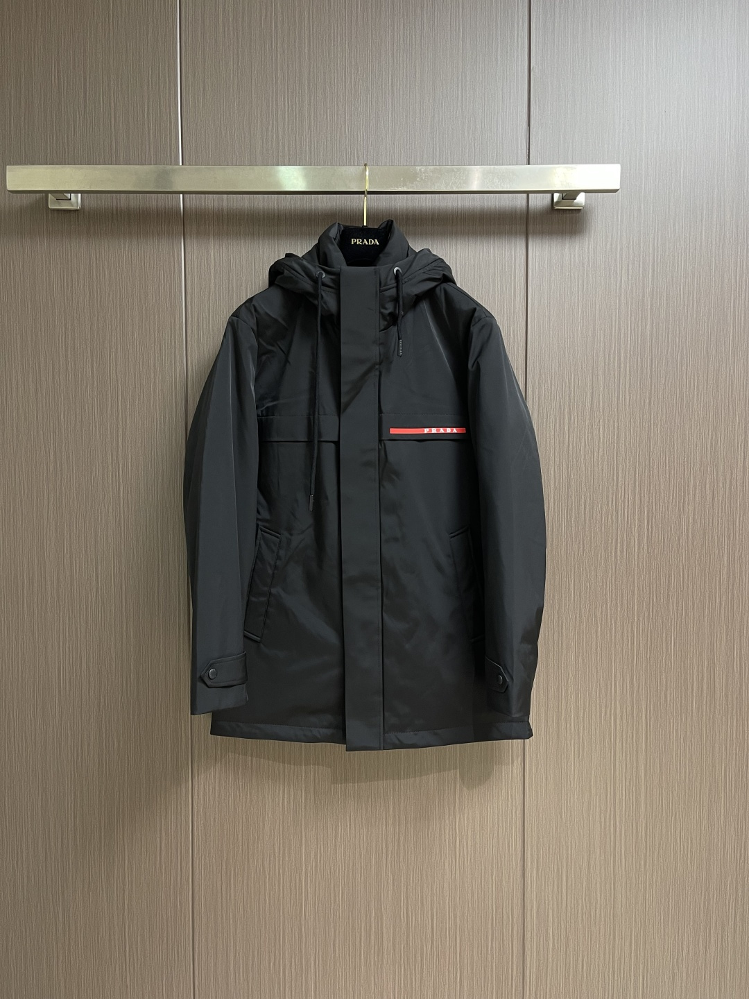 NO:596891,PRADA's new autumn and winter down hooded jacket. The hooded mid-length down jacket is designed with a large coverage area and can provide better warmth in cold weather. The overall style is biased toward casual outdoor style. The shape is stiff and can modify the body shape and is suitable for various body types. The jacket uses high-quality down filling technology and is processed through multiple processes to ensure that the down is evenly distributed and fully fluffy to ensure warmth; it improves durability and optimizes the wearing experience. The imported magic of the cuffs  The patch allows the wearer to freely control the elasticity of the cuffs, relax them casually, and tighten them to prevent wind and warmth. PRADA's iconic red imported tape on the chest enhances brand recognition and fashion sense. From the selection of imported waterproof zippers to the processing of silicone logos, plackets, etc., every detail is strictly controlled, taking into account durability and texture. It is not easy to deform or lose labels after long-term wear. The quality can stand the test, sizes 48-56, prada, jackets  & coats,down jacket,hats,alexander wang19860909PRADA秋冬新款羽绒连帽外套羽绒服,连帽中长款羽绒外套设计,覆盖面积大,在寒冷天气能提供更好的保暖效果.整体风格偏向休闲户外风.版型挺括,能够修饰身形,适合多种身材穿着.外套采用高品质羽绒填充工艺,经多道工序处理,确保羽绒均匀分布、充分蓬松,保障保暖性；提升耐用度,优化穿着体验.袖口的进口魔术贴让穿着者可以自由支配袖口松紧,放宽休闲,收紧防风保暖.胸前PRADA标志性红色进口胶条,提升品牌辨识度与时尚感.从进口防水拉链的选用,到硅胶标识、门襟等等的工艺处理,每处细节都经严格把控,兼顾耐用性与质感,长久穿着不易变形、掉标,品质经得住考验,尺码48-56,,prada,jackets & coats,down jacket,hats,alexander wang,Men's clothing