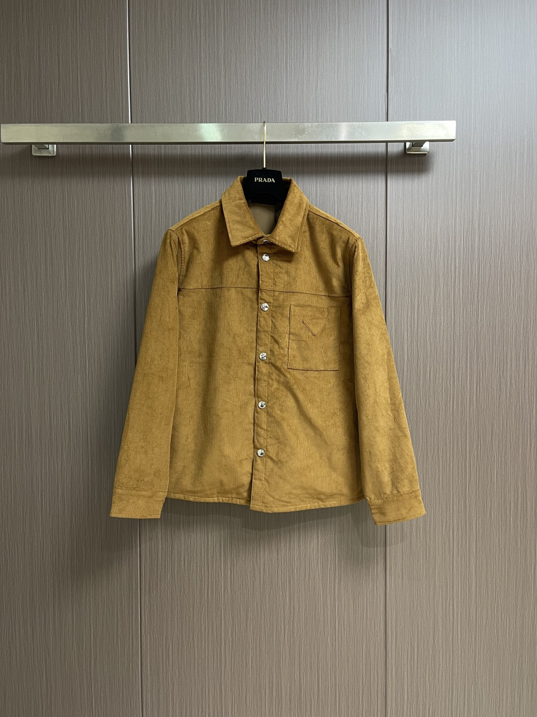 NO:596878,PRADA  The triangle mark corduroy jacket is made of corduroy fabric made of cotton fiber. The fine velvet strips erected on the surface seem to be the delicate texture left by time, with a retro atmosphere. After a special textile process, this rich-textured corduroy is woven. The velvet strips are full and even.  It feels soft and warm, not only has good thermal insulation performance, but also exudes a low-key luxury texture. The chest is decorated with the iconic triangle logo, which becomes the visual focus of the entire piece with a simple and powerful geometric shape. After fine cutting and polishing, the edges are neat and smooth, and the quality is  Full of sense. It is accurately sewn on the left chest, forming a material interaction with the body fabric, which not only highlights the brand identity, but also adds a sense of sophistication to the overall shape. The fitted version design can well modify the body shape, and can be easily created whether it is matched with  Fashionable shape. The front of the body is designed with snap buttons, which makes it easy to put on and take off while also adding a sense of casualness. The snap buttons are of high quality and complement the corduroy fabric. Every detail is done just right. Sizes S-XL, prada, jackets  & coats,alexander wang19860909PRADA 三角标灯芯绒外套,面料采用棉纤维打造的灯芯绒面料,其表面竖起的细密绒条,仿佛是时光留下的细腻纹理,自带复古氛围.经过特殊的纺织工艺,织就出这质感丰盈的灯芯绒.绒条饱满且均匀,触感柔软而温暖,不仅具有良好的保暖性能,还散发着一种低调的奢华质感.胸口饰以标志性的三角徽标,以简约而有力的几何形状,成为整件的视觉焦点.经过精细的裁剪和打磨,边缘整齐光滑,质感十足.它被精准地缝制在左胸位置,与衣身面料形成材质上的互动,既凸显了品牌身份,又为整体造型增添了一份精致感.合身的版型设计,能够很好地修饰身形,无论是搭配还是,都能轻松打造出时尚造型.衣身正面采用按扣开合设计,方便穿脱的同时,也增添了一份随性.按扣的质感上乘,与灯芯绒面料相得益彰,每一个细节都做得恰到好处.尺码S-XL,,prada,jackets & coats,alexander wang,Men's clothing