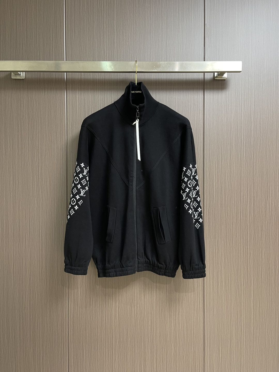 NO:596898,LV SS Autumn and Winter Monogram  Elemental knitted zipper jacket. This black jacket is made of high-density cotton blended fabric, which feels thick and crisp, and is both soft and wear-resistant. The stand-up collar design and metal zipper are both warm and neat. The classic presbyopia pattern on the sleeves is made of fine jacquard.  Craftsmanship, three-dimensional and clear patterns, highlighting brand recognition. The body adopts a loose fit, smooth tailoring, comfortable to wear and free to move. There are large pockets on both sides of the front, taking into account both practicality and decoration. The inside of the collar and cuffs are double-line reinforced.  , to enhance the durability. The brand logo on the chest uses precision embossing technology, and the surface is treated with multiple layers to show a uniform luster, which is in sharp contrast with the black fabric. The inner edge is neatly wrapped, with no excess threads, reflecting the exquisite sewing technology. The overall design is simple and elegant, and the details are exquisite. From the fabric selection to the hardware accessories, every aspect reflects the pursuit of quality, making it an ideal choice for daily wear and outdoor travel. The overall wiring is straight and delicate, the fabric is comfortable and soft, and the colors are consistent and without color difference.  It can be matched with the same style to create a fashionable look, and can be used in various occasions. Customized accessories, complete with three standards, same style for men and women!  Sizes S-XL,,louis vuitton,jackets & coats,jackets & coats,alexander wang19860909LV SS秋冬Monogram 元素针织拉链外套,这件黑色夹克采用高密度棉混纺面料,手感厚实挺括,兼具柔软与耐磨特性.立领设计配合金属拉链,既保暖又显利落.袖子上的经典老花图案采用精细提花工艺,图案立体清晰,彰显品牌辨识度.衣身采用宽松版型,剪裁流畅,穿着舒适且活动自如.前襟两侧设置大口袋,兼顾实用性与装饰性.领口内侧及袖口处均做了双线加固处理,增强耐穿性.胸口位置的品牌徽标,采用精密压印工艺,表面经多层处理,呈现出均匀光泽,与黑色面料形成鲜明对比.内里包边工整,无多余线头,体现了精湛的缝制工艺.整体设计简约大气,细节处理考究,从面料选择到五金配件,每一处都体现了对品质的追求,是日常穿搭与户外出行的理想选择.整体走线平直细腻,面料舒适柔软,颜色一致无色差 能与同款搭配营造时尚造型,驾驭各种场合,定制辅料,三标齐全,男女同款！尺码S-XL,,louis vuitton,jackets & coats,jackets & coats,alexander wang,Men's clothing