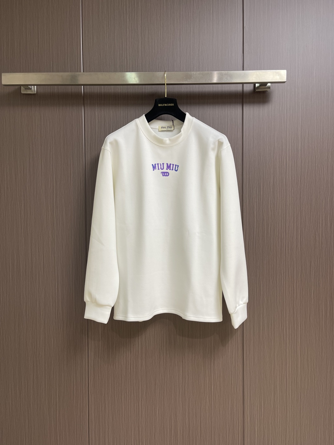 NO:600203,MIUMIU 2025SS round neck long-sleeved T-shirt is made of high-grade 24-count combed cotton yarn. The color uniformity is ensured through the 'first dyeing and then weaving' process. The yarn is double-twisted to improve the pilling resistance, and the cloth surface finish is better than ordinary cotton fabrics. The 190-gram weight of the pattern is precisely controlled and knitted on an 18-needle fine-gauge circular machine, taking into account drape and stiffness. It needs to cooperate with a constant temperature and humidity workshop to avoid yarn tension fluctuations. Compact spinning structure  Drawing on the Swiss Rieter compact spinning technology, the yarn hairiness is reduced by 60, and the fabric density reaches 156 needle inches 2, achieving a baby skin touch while maintaining an elastic recovery rate of more than 8%. Sizes M-3XL, miumiu, tees, t-shirt, alexander wang19860909MIUMIU 2025SS圆领长袖T恤,采用高品级24支精梳棉纱线,通过「先染后织」工艺确保色彩均匀性,纱线经双股加捻提升抗起球性,布面光洁度优于普通棉织物.对版190克重精密调控通过18针细针距圆机编织,兼顾垂坠感与挺括性,需配合恒温恒湿车间避免纱线张力波动.紧密纺结构 借鉴瑞士立达紧密纺技术,纱线毛羽减少60,织物密度达156针英寸2,实现婴儿肌肤触感的同时保持8％以上的弹性回复率.尺码M-3XL,,miumiu,tees，t-shirt,alexander wang,Men's clothing