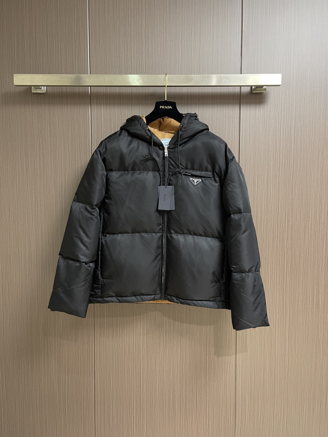 NO:600218,Prada  The nylon color-blocked hooded down jacket is made of regenerated nylon fabric made of nylon. It is woven into a tight and tough fabric through advanced textile technology. It improves the strength of the frame and effectively blocks the invasion of cold wind and locks in the warm air generated by the down layer. After a tight weaving process and  After special treatment, it has functions such as waterproof and windproof, and has a certain lotus leaf effect on the surface. It is also wrinkle-resistant and not easy to deform, making it easy to take care of daily. The outer layer is a regenerated nylon windproof brim in the same color as the body, and the inner lining is made of caramel brown nylon fabric, which forms a strong  The contrasting colors are like pouring molten gold from the setting sun into the deep night sky. There is an adjustable drawstring built into the brim of the hat, and the shape of the hat can be precisely controlled when pulling, taking into account warmth and styling tension. The quilting stitches are sewn with a computer program-controlled machine, and the size of each velvet grid is stable to ensure even distribution of duck down between stitches.  The distance error does not exceed 0.1mm, eliminating the hidden danger of velvet drilling. We use 90 white duck down with a fill power of 650FP to ensure excellent thermal insulation performance. After strict screening and processing, the down is not easy to velvet drilling. Sizes S-XL, prada, down  jacket,hats,alexander wang19860909Prada 尼龙拼色连帽羽绒服,选用锦纶制成的再生尼龙面料,通过先进的纺织技术,编织成紧密且坚韧的布料,提升骨架强度有效阻挡冷风侵袭,锁住羽绒层产生的暖空气,经过紧密的编织工艺和特殊处理之后使其具备防水防风等功能,表面形成一定的荷叶效应,同时抗皱不易变形,易于日常打理.外层与衣身同色的再生尼龙防风帽檐,内衬选用焦糖棕色尼龙面料,翻折时形成强烈色彩对冲,宛如将落日熔金注入深邃夜空.帽檐内置可调节抽绳,拉动间精准控制帽型,兼顾保暖与造型张力.绗缝线迹以电脑程控机缝制,每个绒格尺寸稳定,确保鸭绒均匀分布,针脚间距误差不超过0.1mm,杜绝钻绒隐患.选用90白鸭绒,蓬松度达650FP,确保保暖性能卓越.绒子经过严格筛选与处理之后,不易钻绒.尺码S-XL,,prada,down jacket,hats,alexander wang,Men's clothing