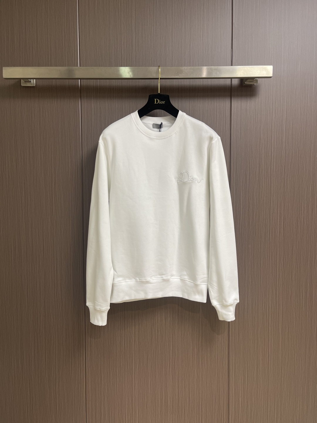 NO:646922,Dior CD Ribbon crew neck sweatshirt, new for the Spring 2026 collection, decorated with Ribbon  The logo pays tribute to the exquisite craftsmanship of the workshop. It is carefully made of white cotton fleece fabric, with ribbed round neck, cuffs and hem. The casual silhouette can be matched with the oversized version. It is made of a composite of 26-count double yarn top layer + 10-count bottom yarn terry  Structure, a uniform suede surface is formed on the inside through precision raising process, achieving a velvet-like skin-friendly touch. The heavy weight gives the fabric a sculpture-like stiffness, perfectly balancing the lazy silhouette and neat lines. The collar and cuffs are made of 21 2x2 reinforced ribs.  , a memory elastic mesh is formed by weaving in both warp and weft directions to ensure that the initial fit is maintained after multiple wears and takeoffs. The process uses laser-cut ribbons and micron-level hot-melt composite technology, and is processed through positioning embroidery. The edges achieve seamless fit with precision, and the decorative belt is fixed on the chest. Its luster forms a subtle light and shadow dialogue with the cotton matte base, and the detailed specifications are restored to the version. Sizes XS-L, dior, hoodie, sweatshirts, alexander  wang19860909Dior CD Ribbon 标志圆领卫衣,二零二六春季系列新品,饰以Ribbon 标志,向工坊的精湛工艺致敬.采用白色棉质起绒面料精心制作,搭配罗纹圆领、袖口和底边.休闲廓形,可与超大版型搭配.采用26支双纱面层＋10支底纱毛圈的复合结构,通过精密起绒工艺在内侧形成均匀绒面,实现天鹅绒般亲肤触感.重磅克重赋予面料雕塑般挺括感,完美平衡慵懒廓形与利落线条.领口袖口采用21支2x2强化罗纹,以经纬双向编织形成记忆弹性网,确保多次穿脱仍保持初始贴合度.工艺采用激光切割缎带与微米级热熔复合技术,通过定位刺绣工艺处理.边缘实现精度的无缝贴合,装饰带固定于前胸,其光泽与棉质哑光基底形成微妙的光影对话,对版还原细节规格.尺码XS-L,,dior,hoodie,sweatshirts,alexander wang,Men's clothing