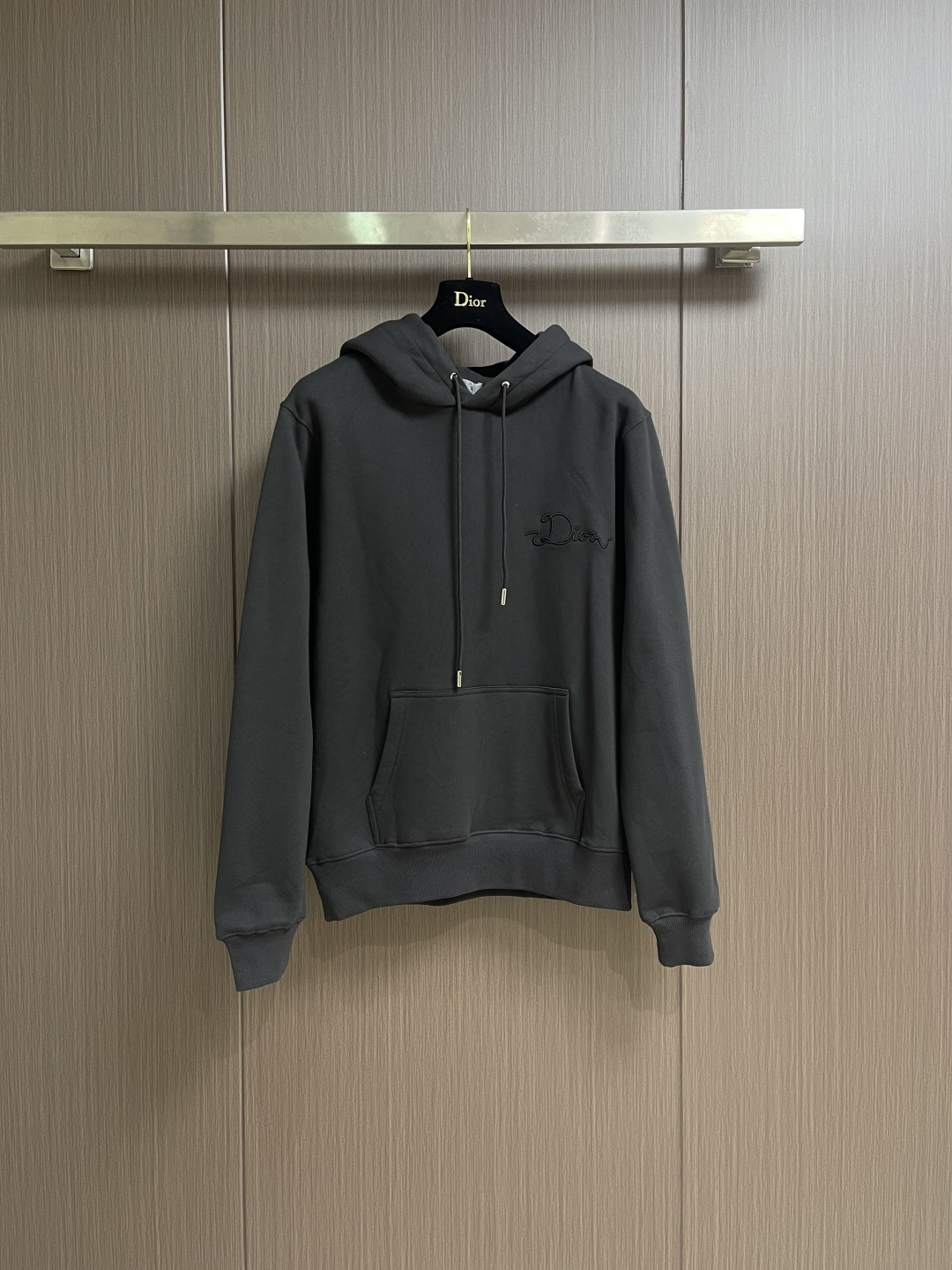 NO:646916,Dior woven satin badge hooded sweatshirt, cotton pile terry fabric, pure cotton texture fabric is made of 26-count double yarn + 10-count base yarn terry fabric, weight 380gm2; matched with 21-count 2x2 Rib, the composition is 95% cotton and 5% spandex; 2.26-count double yarns with a weight of 380gm are used as surface yarns, and the yarns are thinner, ensuring the smooth and smooth appearance of the fabric and good color fastness; while 10-count base yarns are used as terry yarns, and the yarns are thicker, forming loose coils during weaving. After unified raising or brushing treatment in the later stage, a layer of rich, dense and soft velvet is formed on the inside of the fabric. The high weight of wool gives the sweater a heavy drape and crisp texture, making it less prone to wrinkles and stronger styling capabilities. The pure cotton material ensures excellent breathability, moisture absorption and skin-friendly feeling, and the final white color appears pure and rich in texture. The ribbon letter embroidery process brings a multi-dimensional texture. The ribbon itself has a silky luster and smooth touch, which is similar to the matte plush feel of the suede surface of the sweater. A sharp and high-end contrast. The embroidery decoration in the form of ribbons is fixed on the fabric through special processing. The texture brought by this process is usually different from the woven texture and slight luster of the main knitted fabric. It forms a delicate and accessible visual and tactile focus on the matte dark gray base, which enhances the craftsmanship and uniqueness of the single product. Hooded drawstring loose fit design . The classic drawstring hoodie is embellished with an engraved bell, and the hood is equipped with engraved hardware accessories; the cuff threads are the same color as the hood. Restore the original design H silhouette, with kangaroo pockets and open-stitch pockets; the sleeve length is longer than normal for more effect, highlighting the casual sex of the upper body. Sizes XS-L, dior, hoodie, sweatshirts, hats, alexander wang19860909Dior 织缎徽章连帽卫衣,棉质起绒毛圈面料,纯棉质感面料采用26支双纱＋10支底纱的毛圈绒面料,克重380gm2；搭配采用21支 2x2 罗纹,成分為95％棉与5％氨纶；克重380gm2.26支双纱作为表面纱线,纱线更细,确保了面料外观的细腻平整与良好的色牢度；而10支底纱作为毛圈纱,纱线更粗,在织造时形成松散的线圈,经后期统一的起绒或刷绒处理后,在面料内侧形成一层丰厚、浓密且柔软的绒毛.的高克重赋予了卫衣重磅的垂坠感和挺括的骨感,使其不易褶皱,造型能力更强.纯棉的材质保证了极佳的透气性、吸湿性和亲肤感,最终的白色呈现纯净且富有质感.缎带字母刺绣工艺,工艺带来的多维度质感.缎带本身具有丝质的光泽与顺滑触感,与卫衣起绒面的哑光毛绒感形成鲜明而高级的对比.缎带形式的刺绣装饰,通过工艺特殊处理,使织带固定在面料上.这种工艺带来的质感通常是不同于主体针织面料的梭织质感与轻微光泽,在哑光的深灰色底上形成一个精致而触手可及的视觉与触觉焦点,提升了单品的工艺设计和独特性.连帽抽绳宽松版型设计.经典抽绳帽衫刻字吊钟点缀,帽口设有刻字五金配件；袖口螺纹与帽位同色同缸.还原版型设计H廓形,配合袋鼠袋明线口袋；袖长比常规偏长一些更有效果,突出上身的随性感.尺码XS-L,,dior,hoodie,sweatshirts,hats,alexander wang,Men's clothing