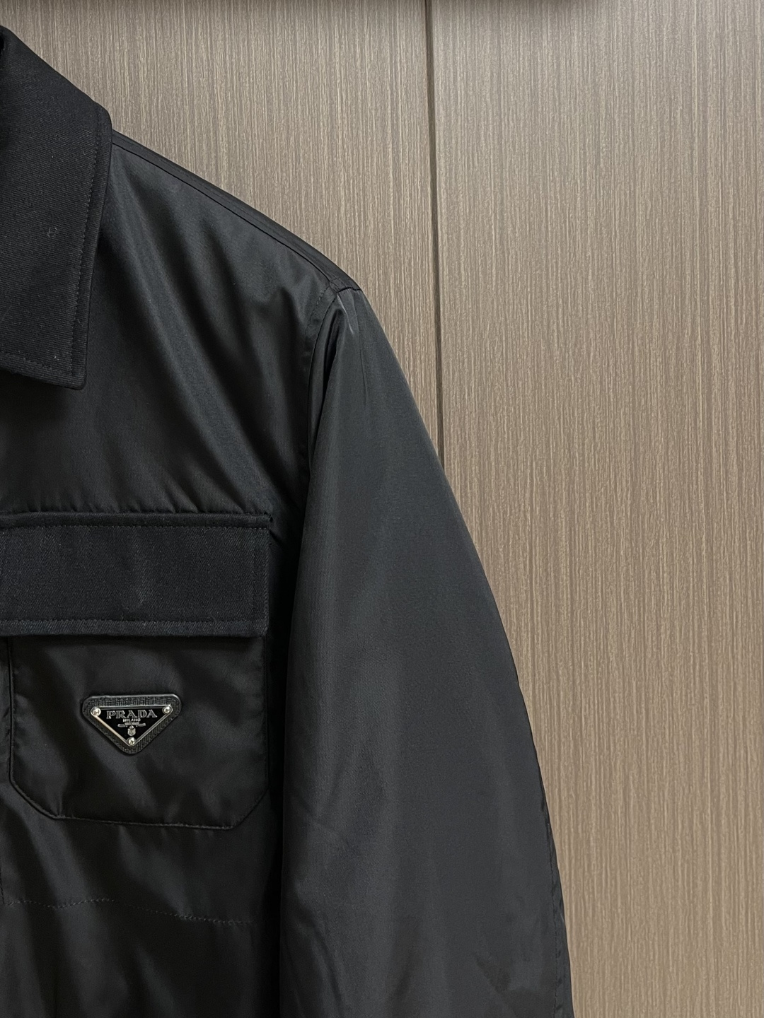 Prada 纯色标志徽标拉链翻领长袖夹克外套，这款Prada夹克采用高品质防水防风面料，手感挺括且透气性