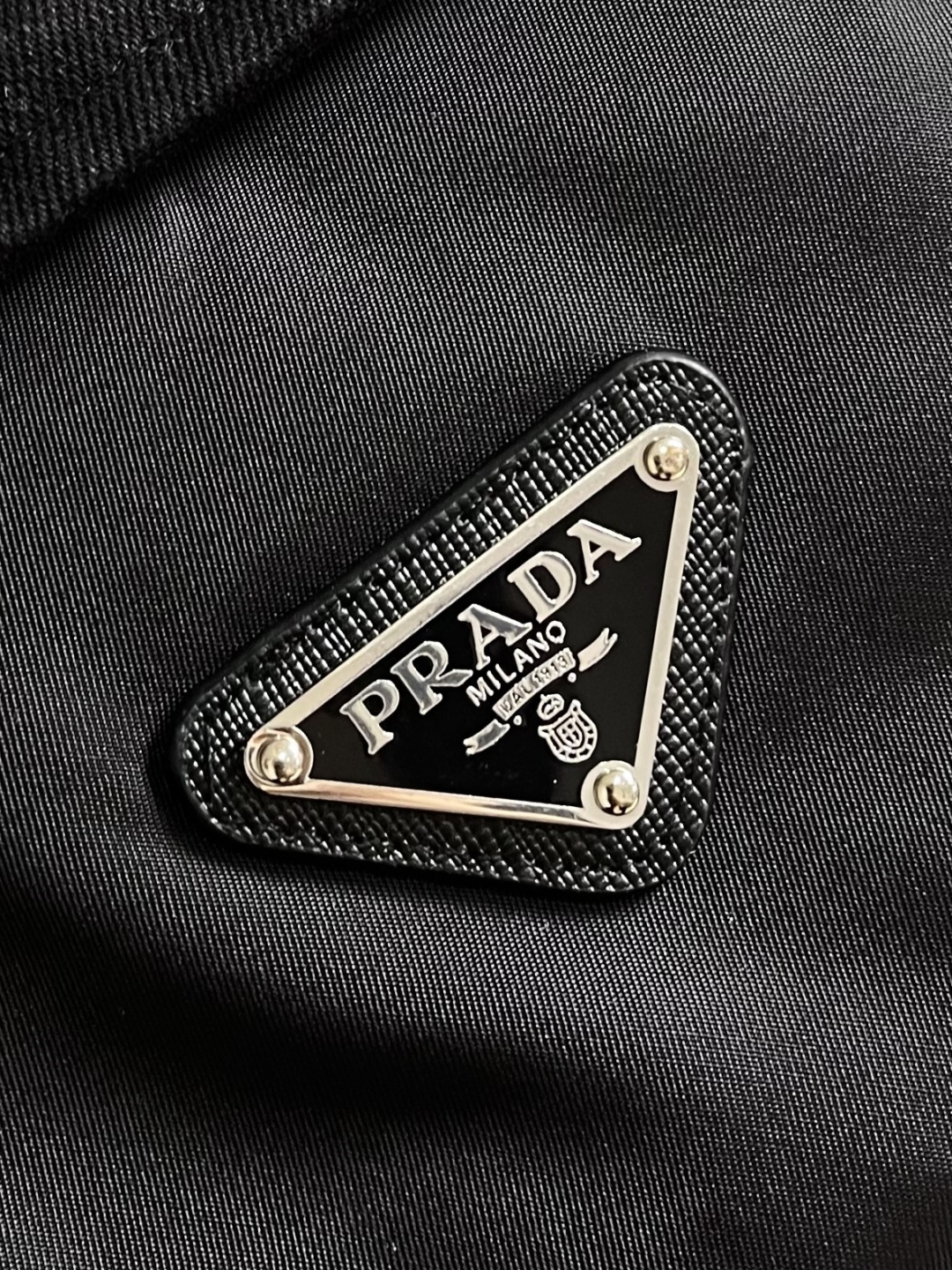 Prada 纯色标志徽标拉链翻领长袖夹克外套，这款Prada夹克采用高品质防水防风面料，手感挺括且透气性