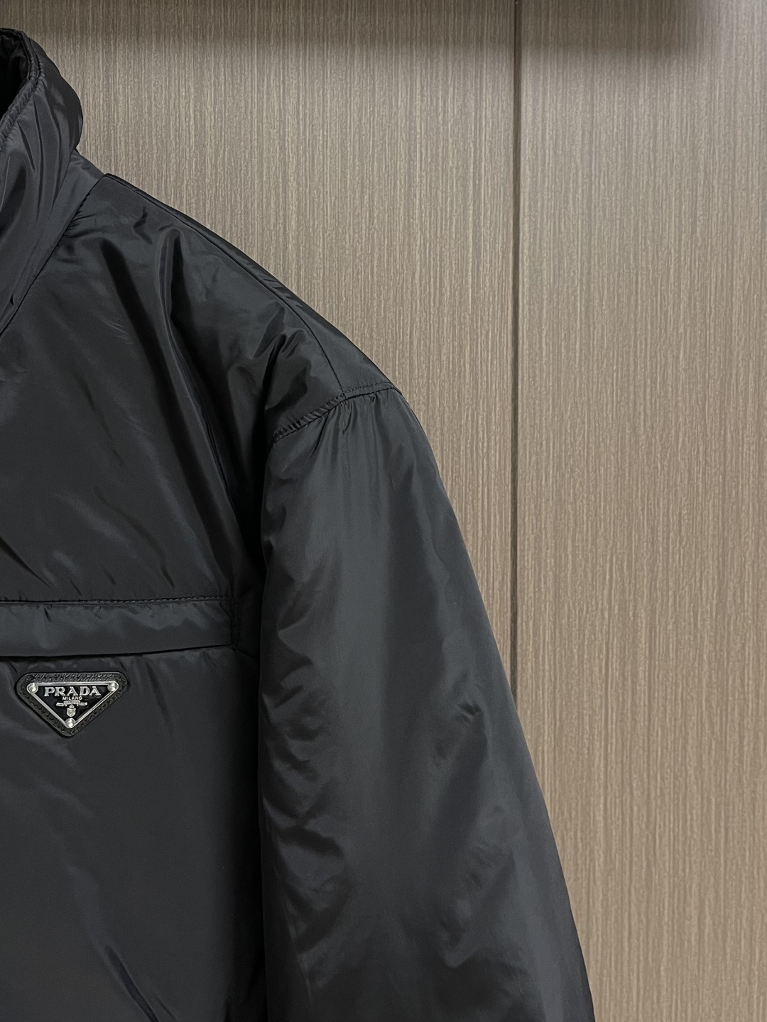 PRADA 2025FW秋冬新款连帽羽绒外套，选用品牌标志性的再生尼龙面料，与传统尼龙性能相当，具备高强