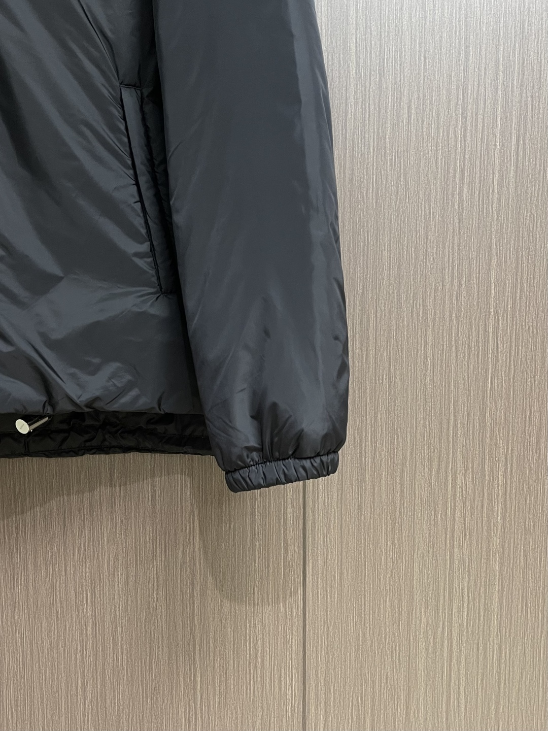 PRADA 2025FW秋冬新款连帽羽绒外套，选用品牌标志性的再生尼龙面料，与传统尼龙性能相当，具备高强