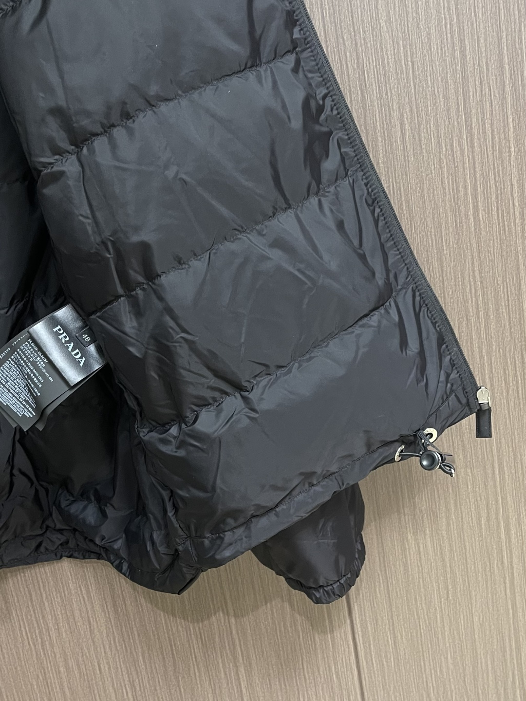 PRADA 2025FW秋冬新款连帽羽绒外套，选用品牌标志性的再生尼龙面料，与传统尼龙性能相当，具备高强