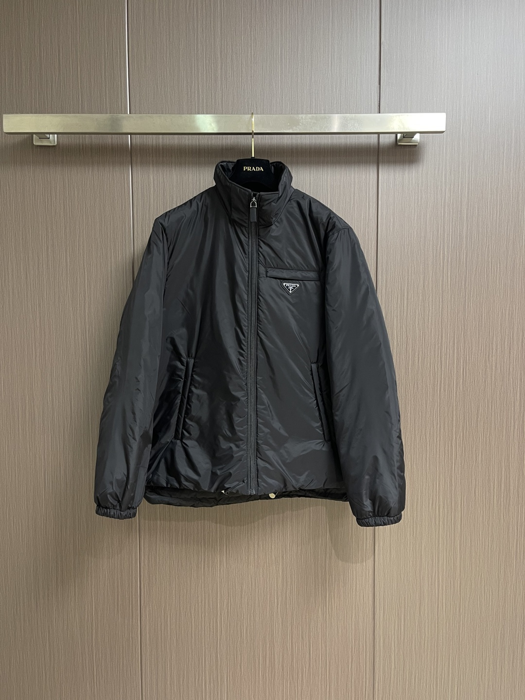 PRADA 2025FW秋冬新款连帽羽绒外套，选用品牌标志性的再生尼龙面料，与传统尼龙性能相当，具备高强