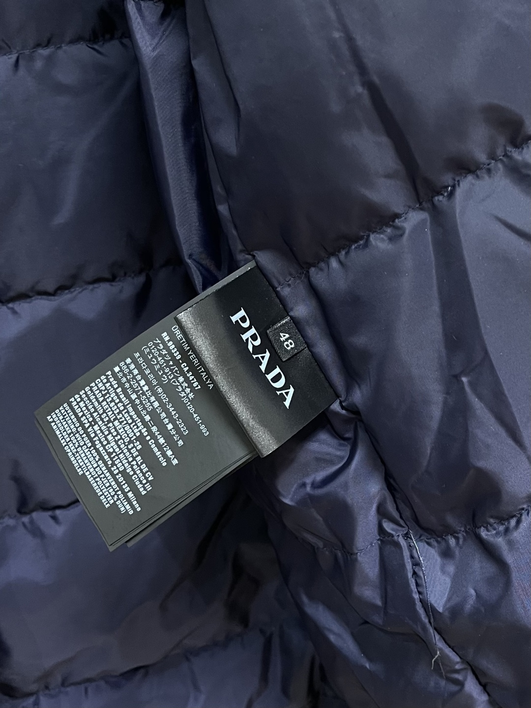 PRADA 2025FW秋冬新款连帽羽绒外套，选用品牌标志性的再生尼龙面料，与传统尼龙性能相当，具备高强