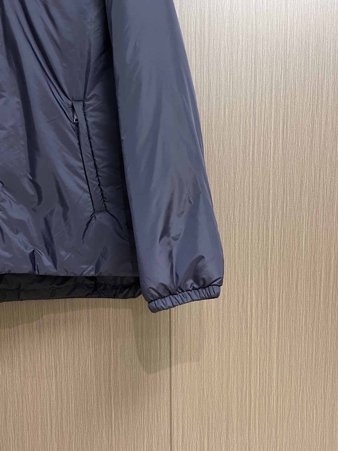 PRADA 2025FW秋冬新款连帽羽绒外套，选用品牌标志性的再生尼龙面料，与传统尼龙性能相当，具备高强