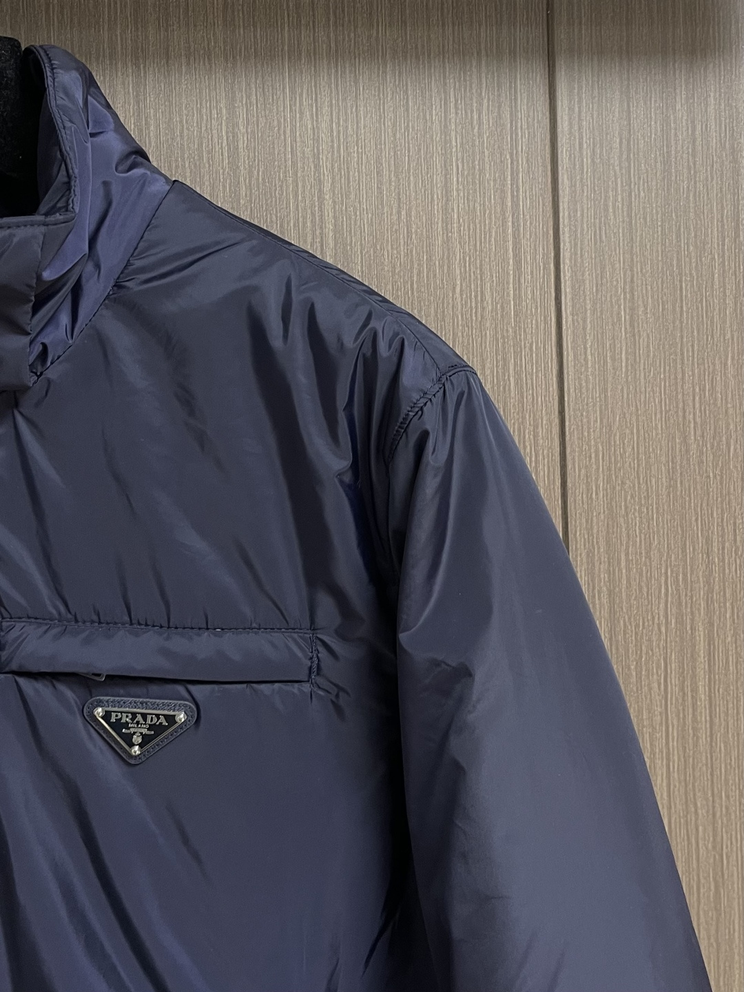 PRADA 2025FW秋冬新款连帽羽绒外套，选用品牌标志性的再生尼龙面料，与传统尼龙性能相当，具备高强