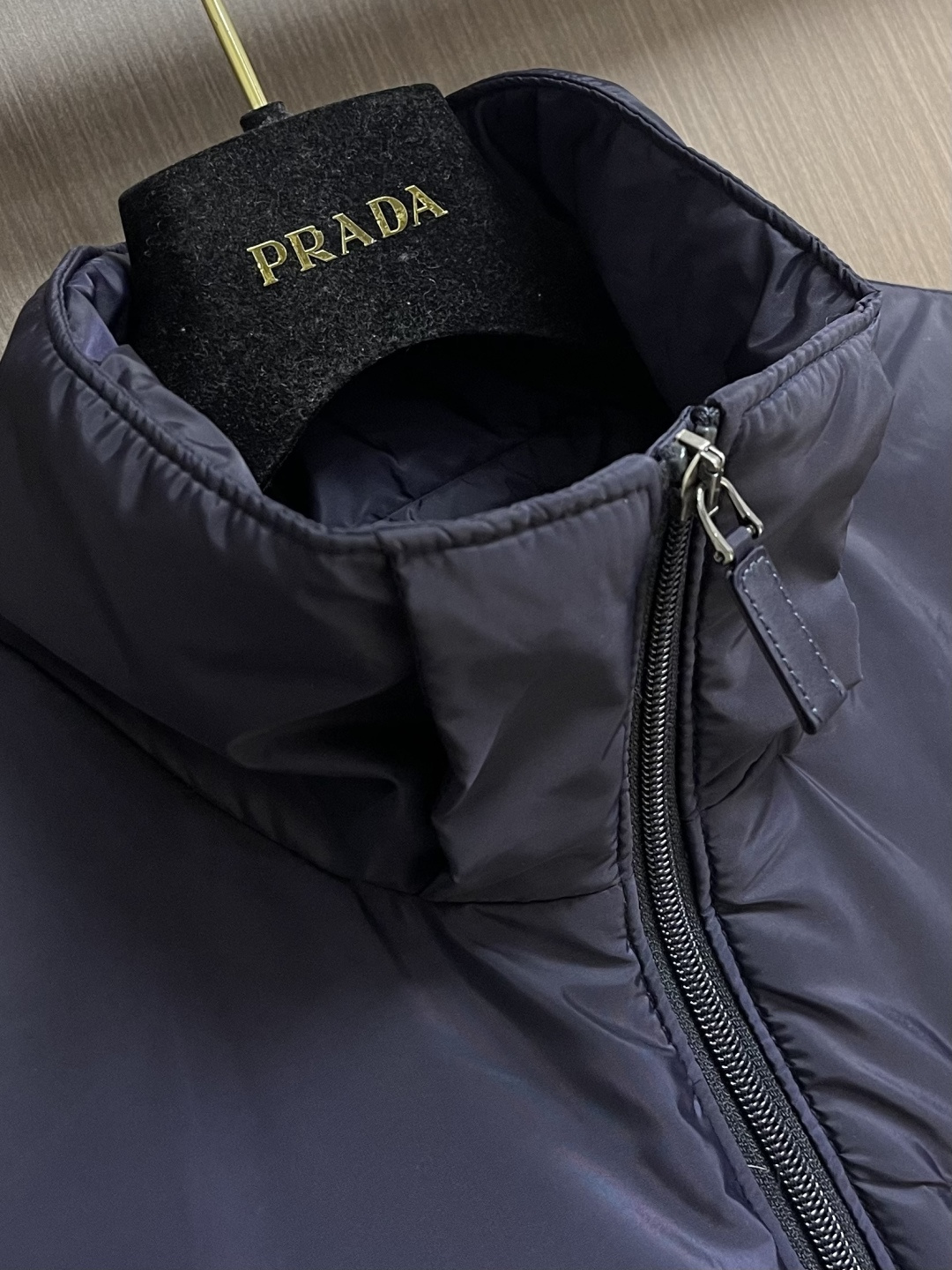 PRADA 2025FW秋冬新款连帽羽绒外套，选用品牌标志性的再生尼龙面料，与传统尼龙性能相当，具备高强